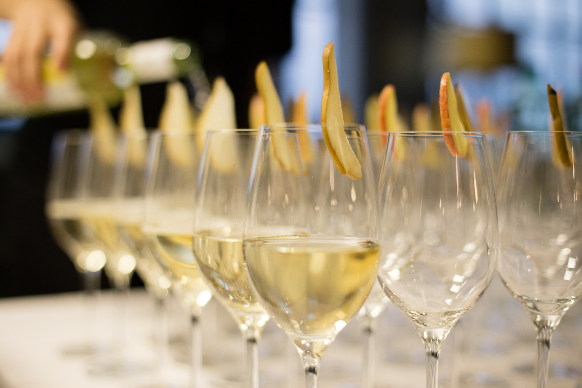 Detailaufnahme von Weingläsern mit Weißwein.