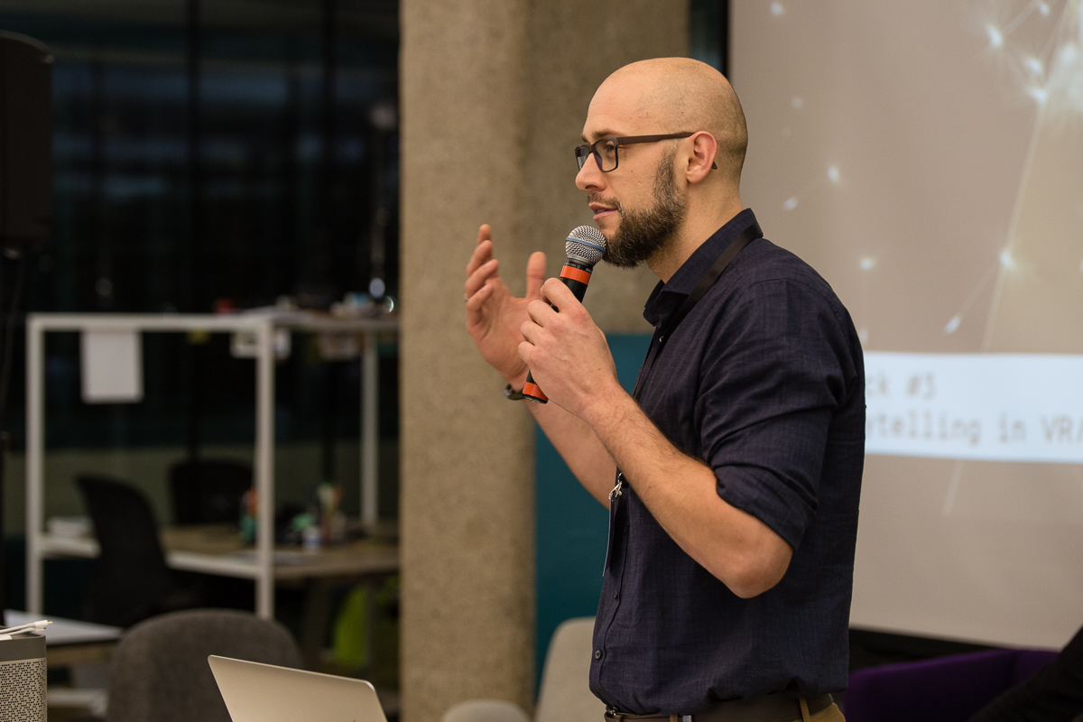 Markus Pragfrieder hält einen Vortrag vor einer Leinwand, er spricht in ein Mikrofon.