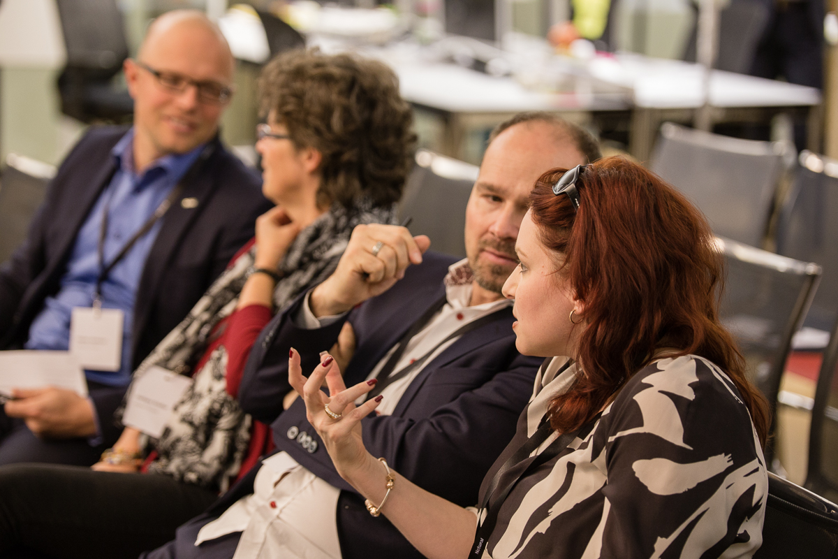 Personen im Publikum unterhalten sich miteinander.