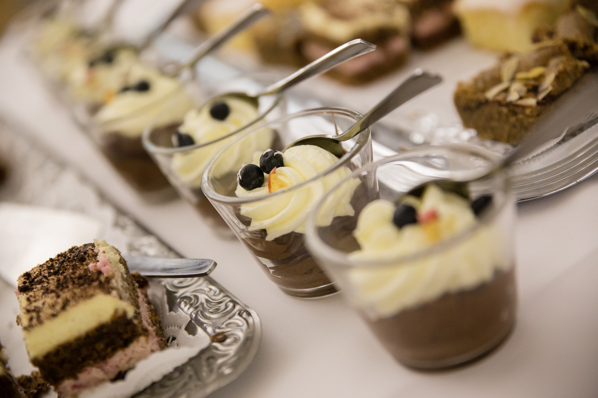 Detailaufnahme von Dessertgläsern, darin befindet sich eine Schokoladencreme mit Schlagsahne und Beeren.