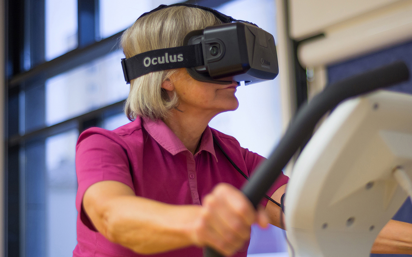 Frau mit Oculus VR-Brille trainiert auf einem Heimtrainer in einem modernen Raum.