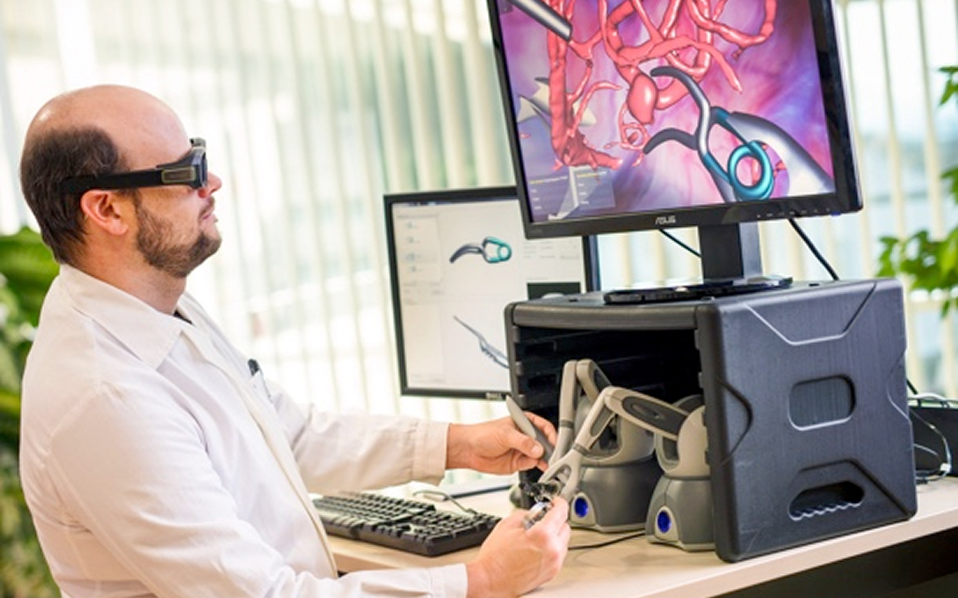 Arzt mit 3D-Brille steuert medizinischen Simulator mit Joysticks, auf dem Bildschirm ist eine Gefäßstruktur zu sehen.