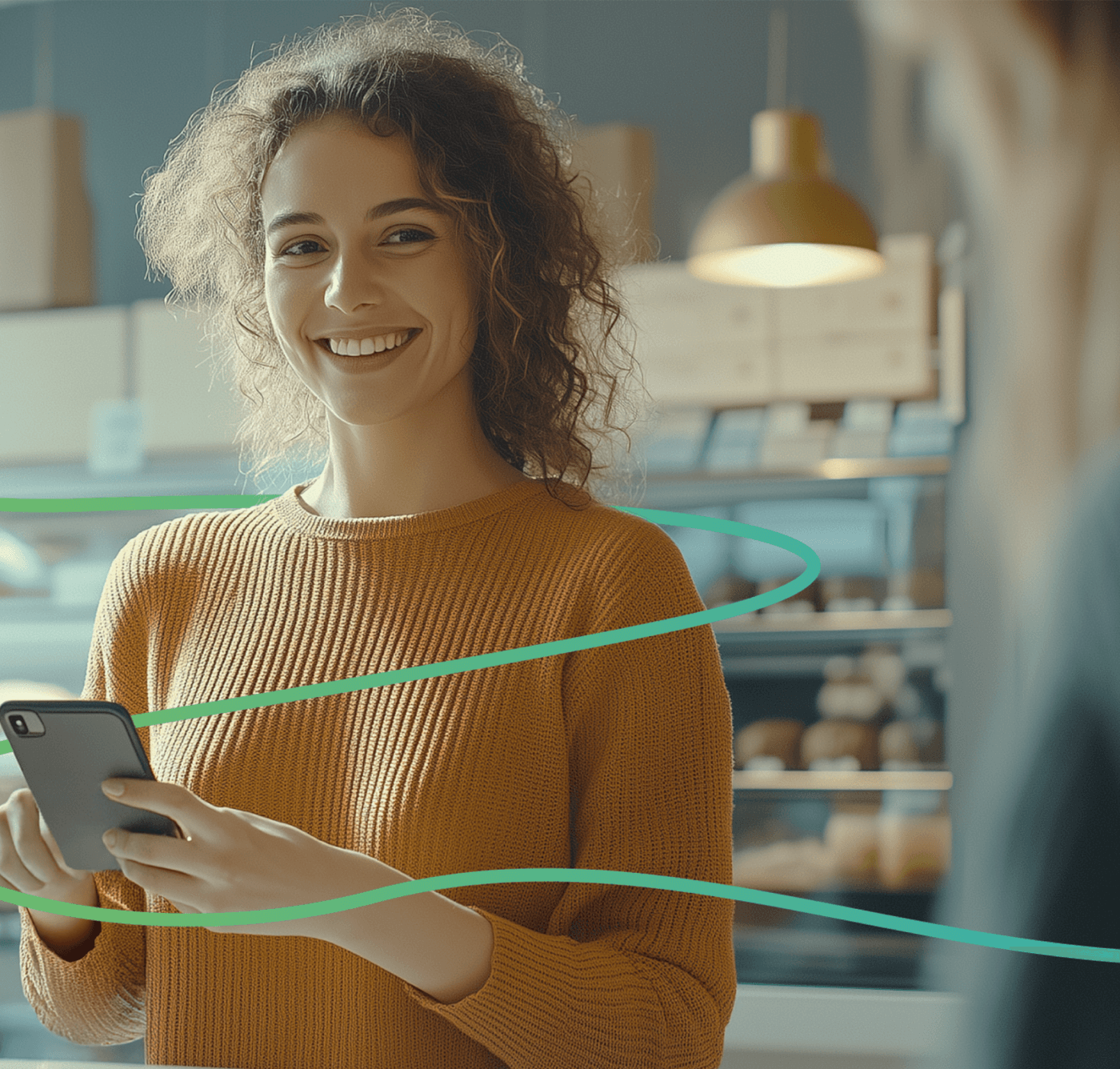 Junge Frau in Bäckerei lächelt und hält ein Smartphone in der Hand, grüne Linie symbolisiert digitale Verbindung.