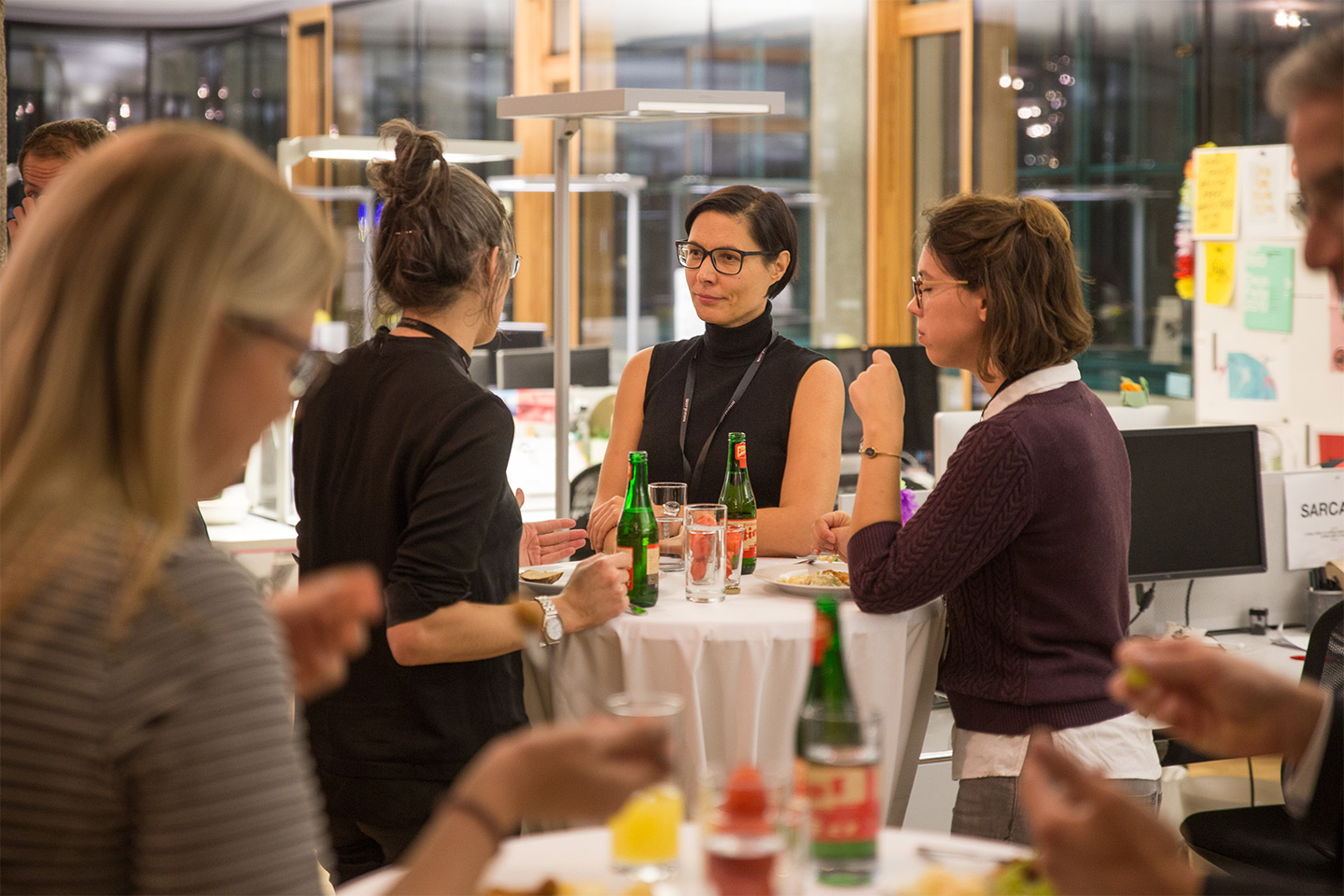 Three women (Elisabeth Kneidinger, Judith Sambs, and Maria Baaske) are talking at a high table, with another blurred woman in the foreground.