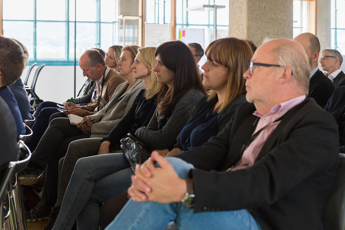 The audience listens intently to the speakers.