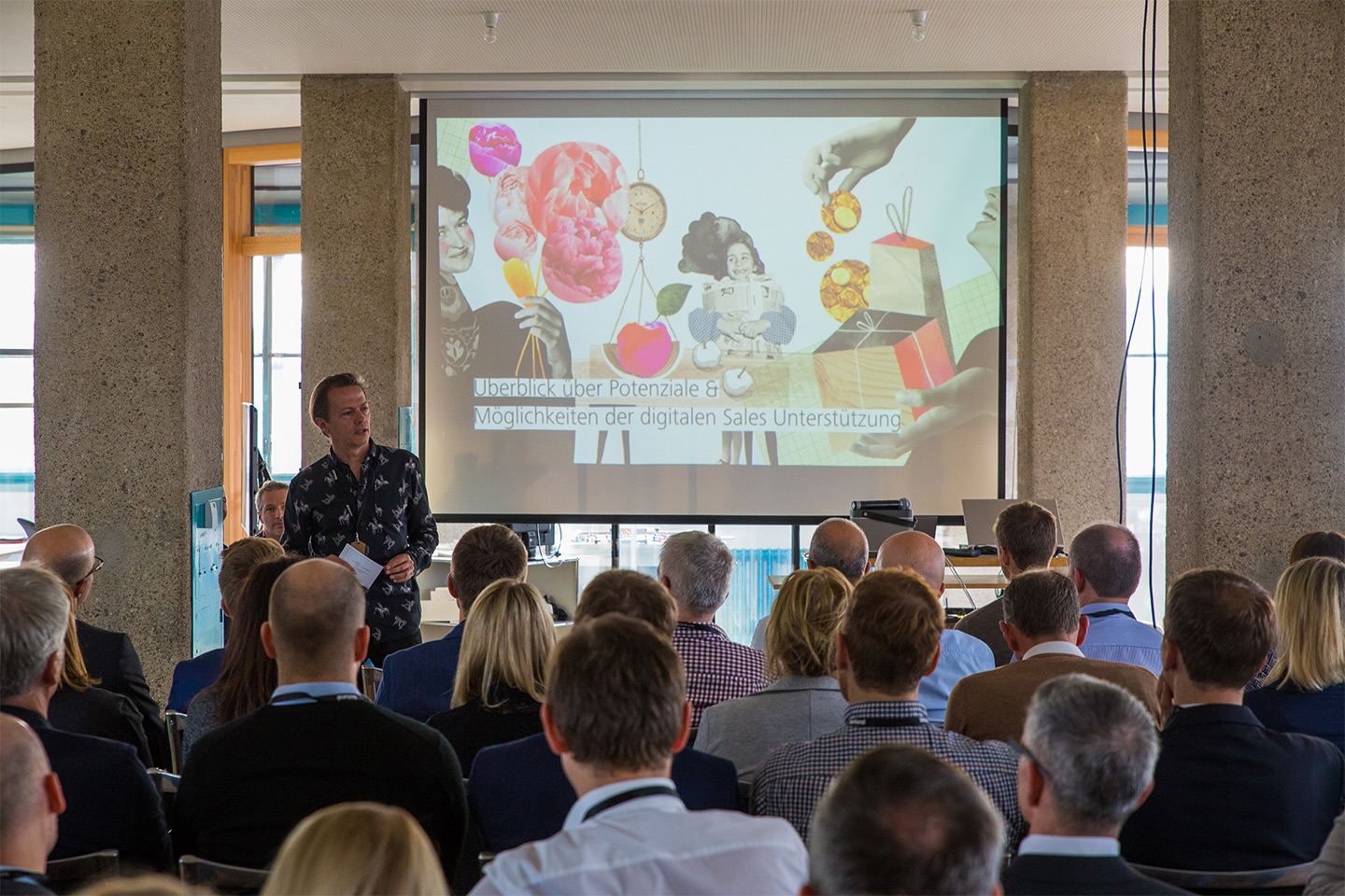 Shot of Ernst Demmel (Netural) in front of the screen and the audience.