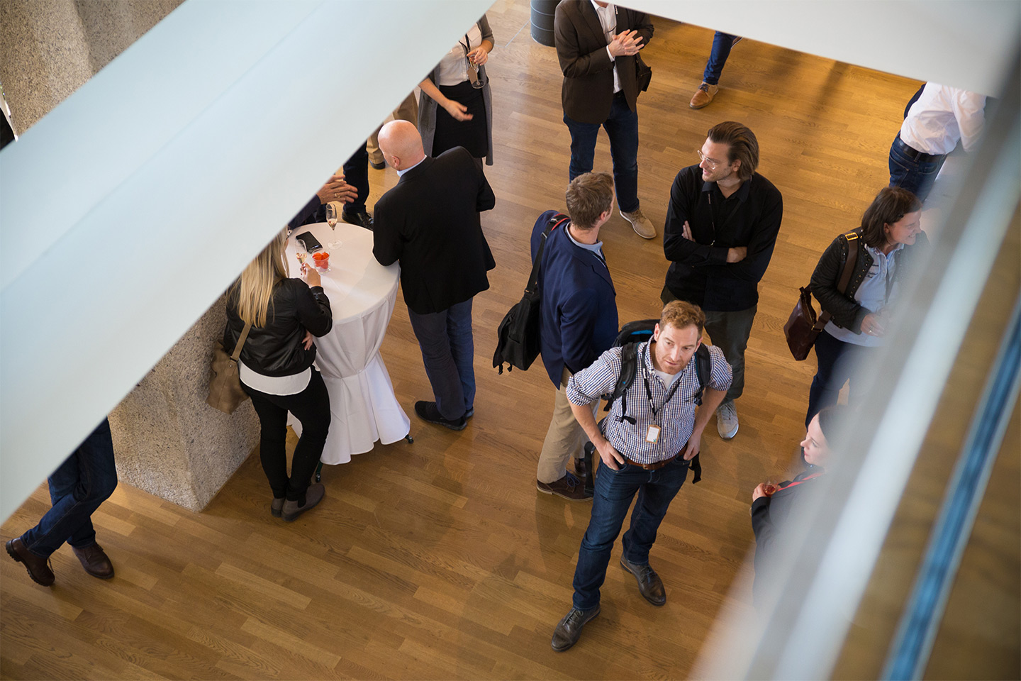 Top-down shot of the audience, who are engaged in lively conversation.
