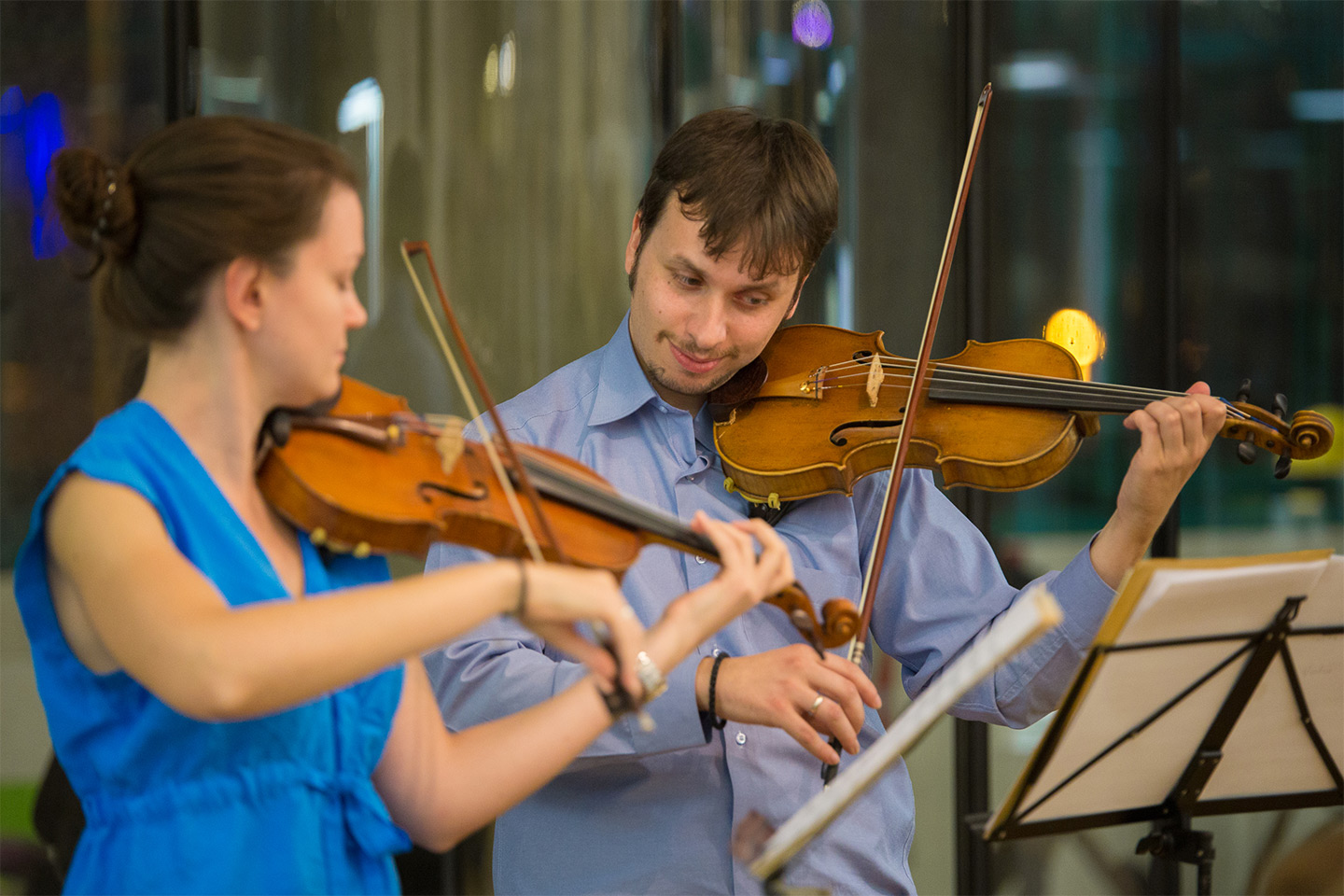 A woman and a man play the violin.