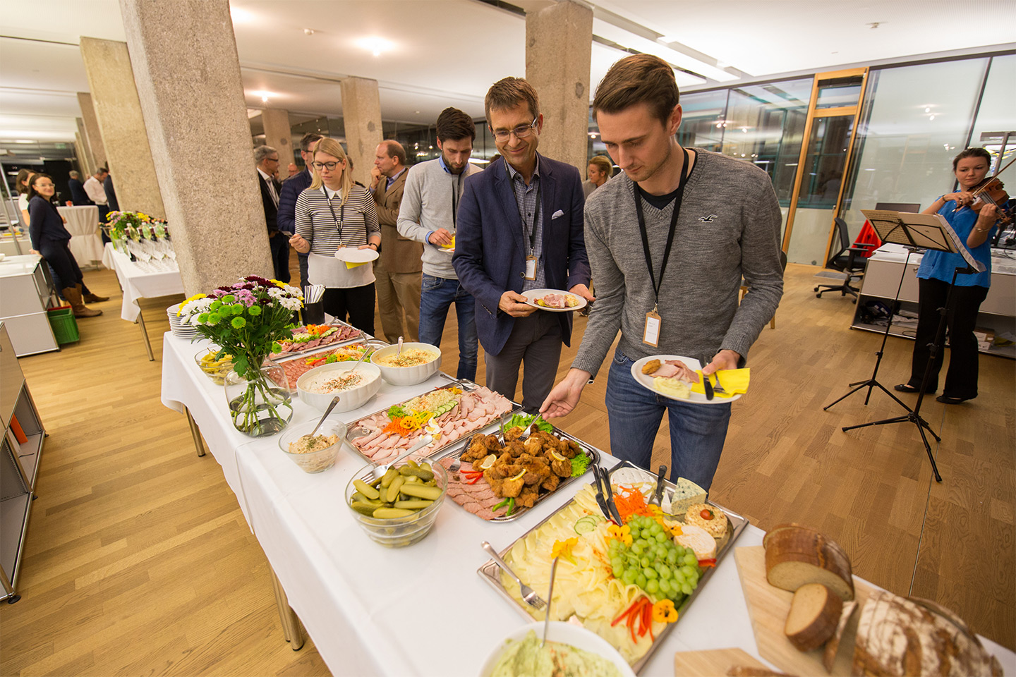 A buffet with a large selection, several people are queuing and serving themselves.