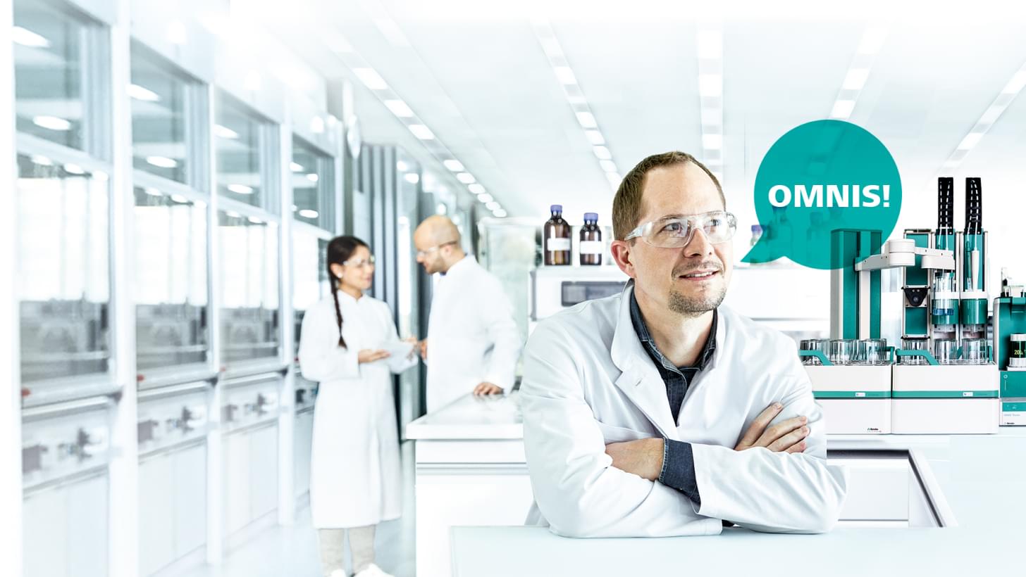 A man with a white lab coat, next to him a speech bubble saying "Omnis!", in the background are two other people talking.
