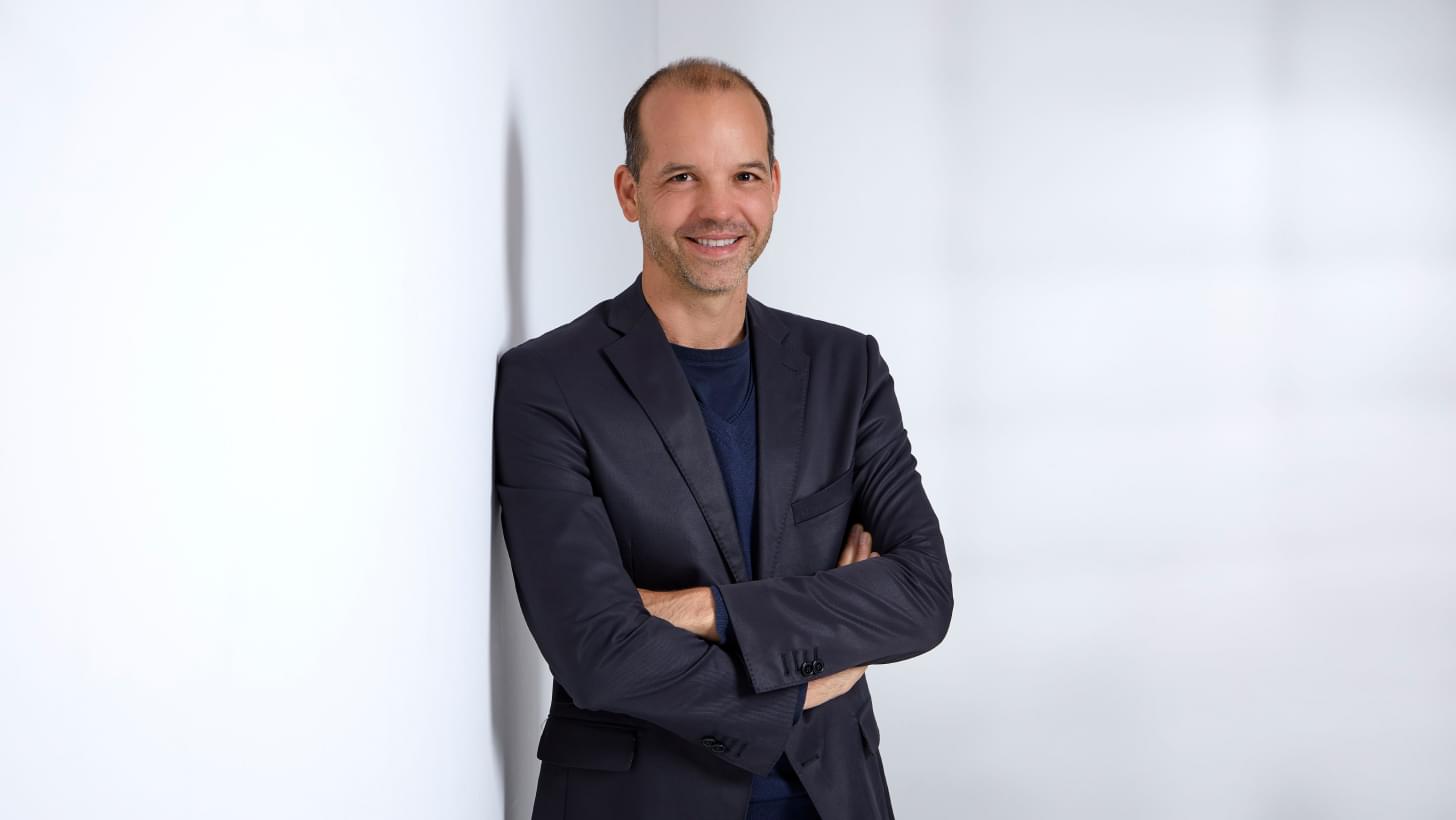 Ein Portrait von Netural CEO Albert Ortig, er steht vor einem weißen Hintergrund und blickt lächelnd in die Kamera.