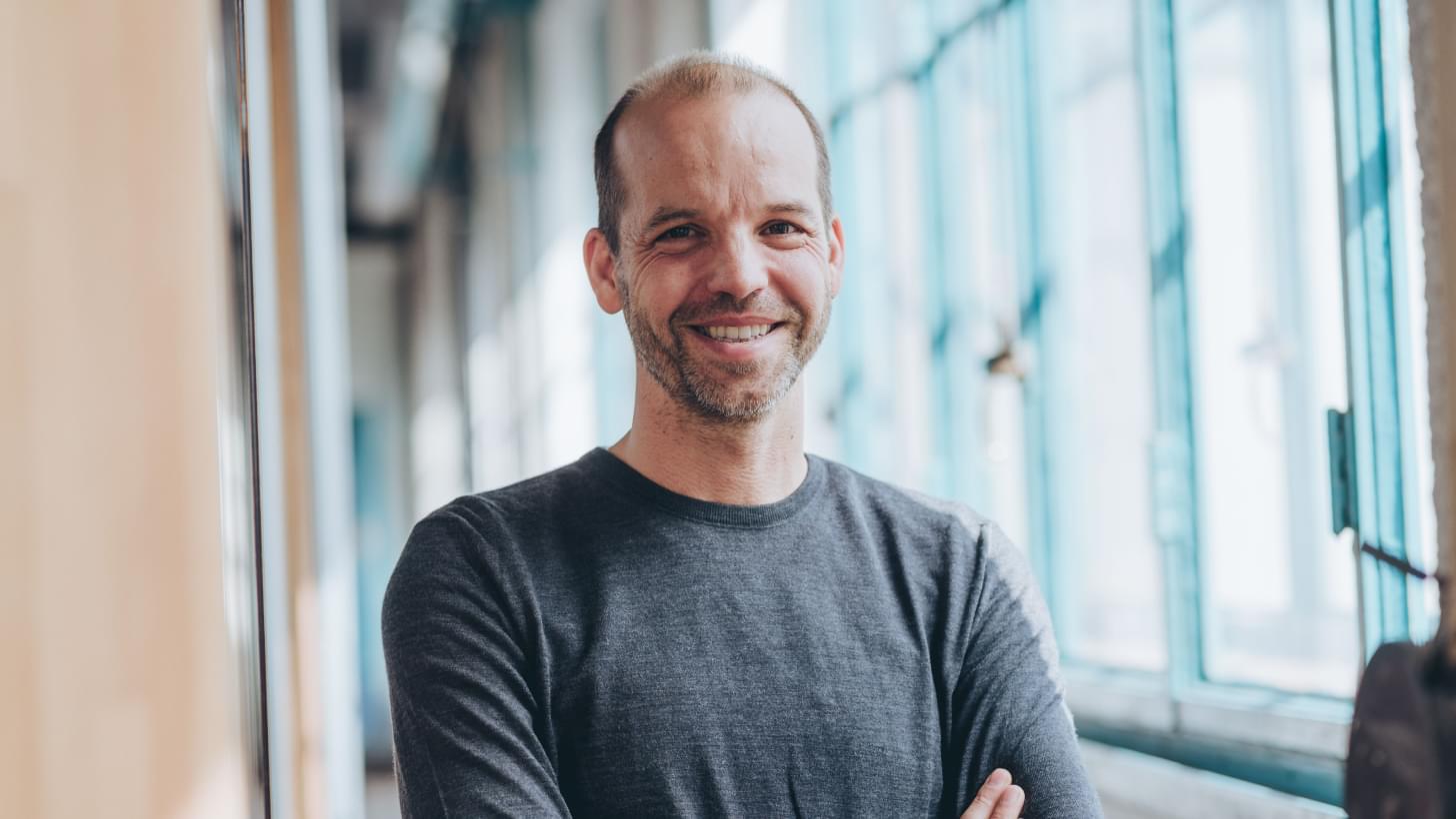 Portrait von Netural CEO Albert Ortig vor Fenstern der Tabakfabrik Linz