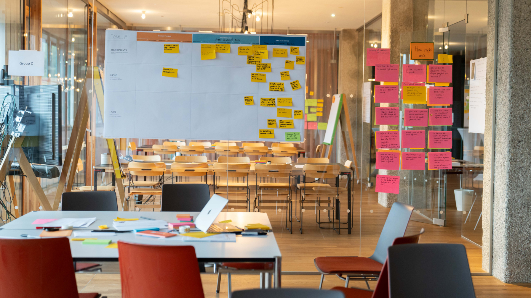Ein leerer, moderner Meetingraum im Netural-Büro mit Whiteboards und Glaswänden, die voller Notizzettel sind.