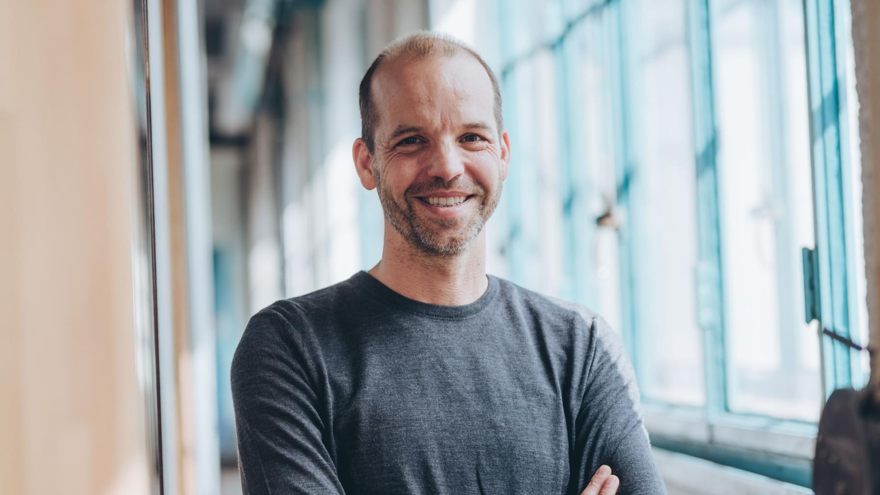 Portrait von Netural CEO Albert Ortig vor Fenstern der Tabakfabrik Linz
