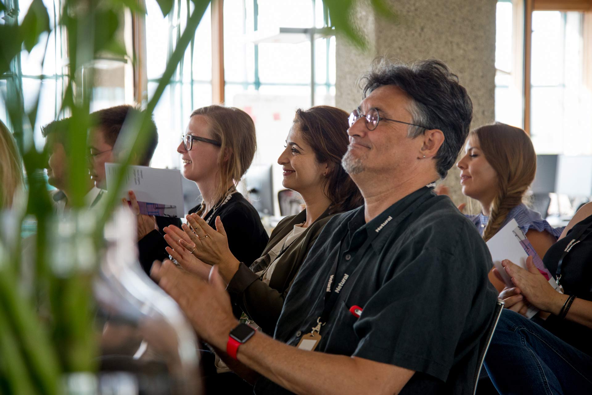 The audience applauds, with a focus on Robert Hartmann, a Netural employee.