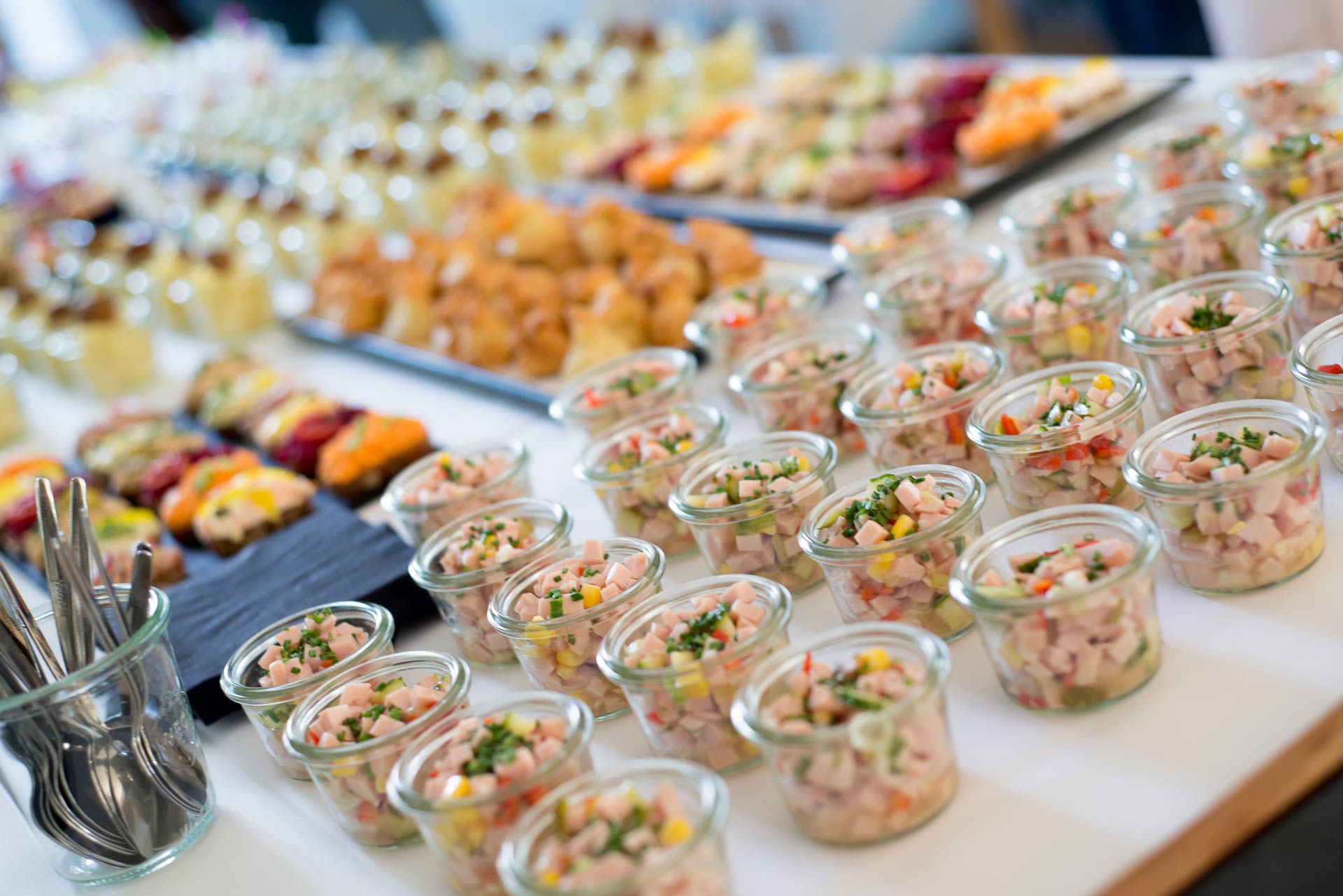 Close-up of various appetizers served in glass jars.