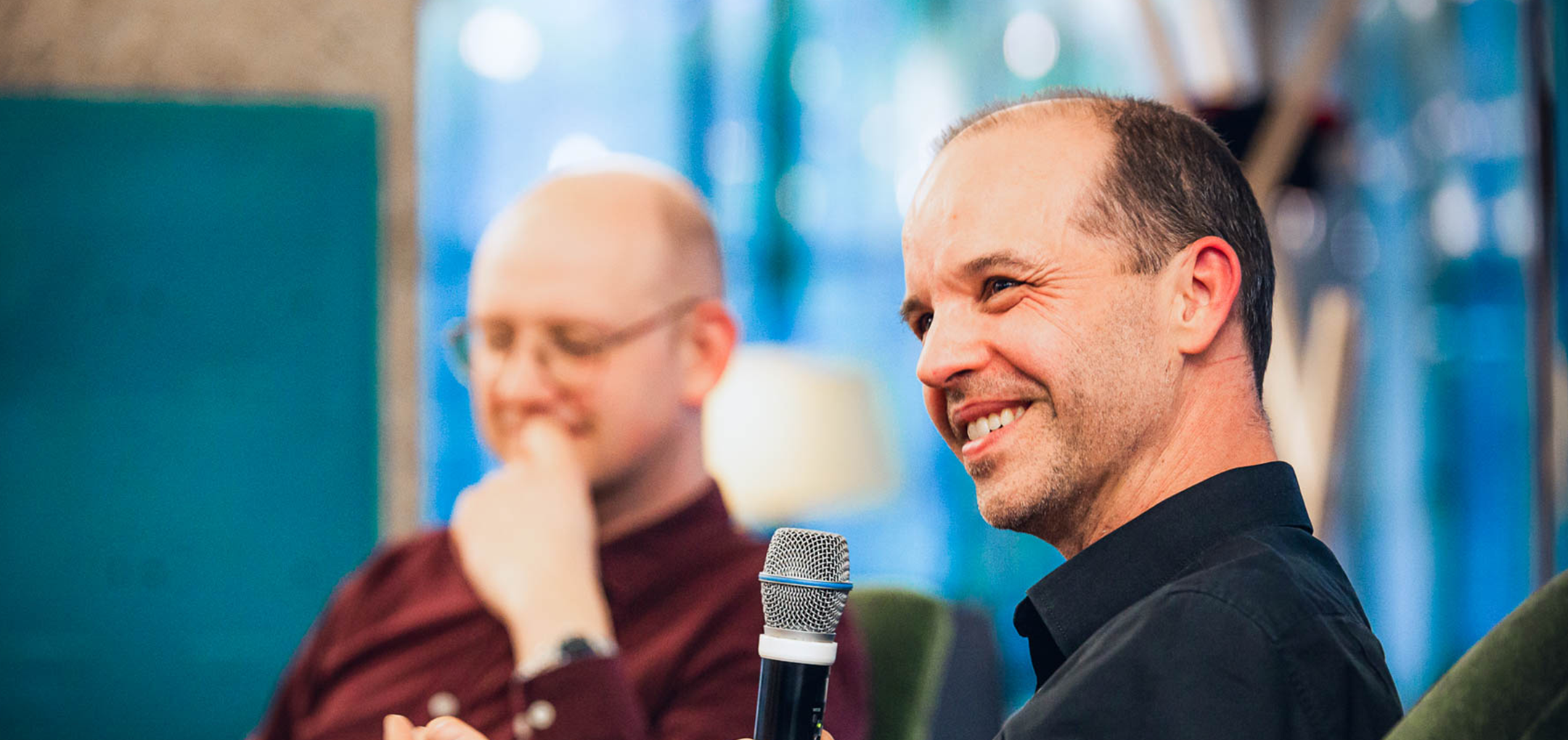 Albert Ortig spricht ins Mikrofon, im Hintergrund Thomas Gegenhuber nachdenklich lächelnd.