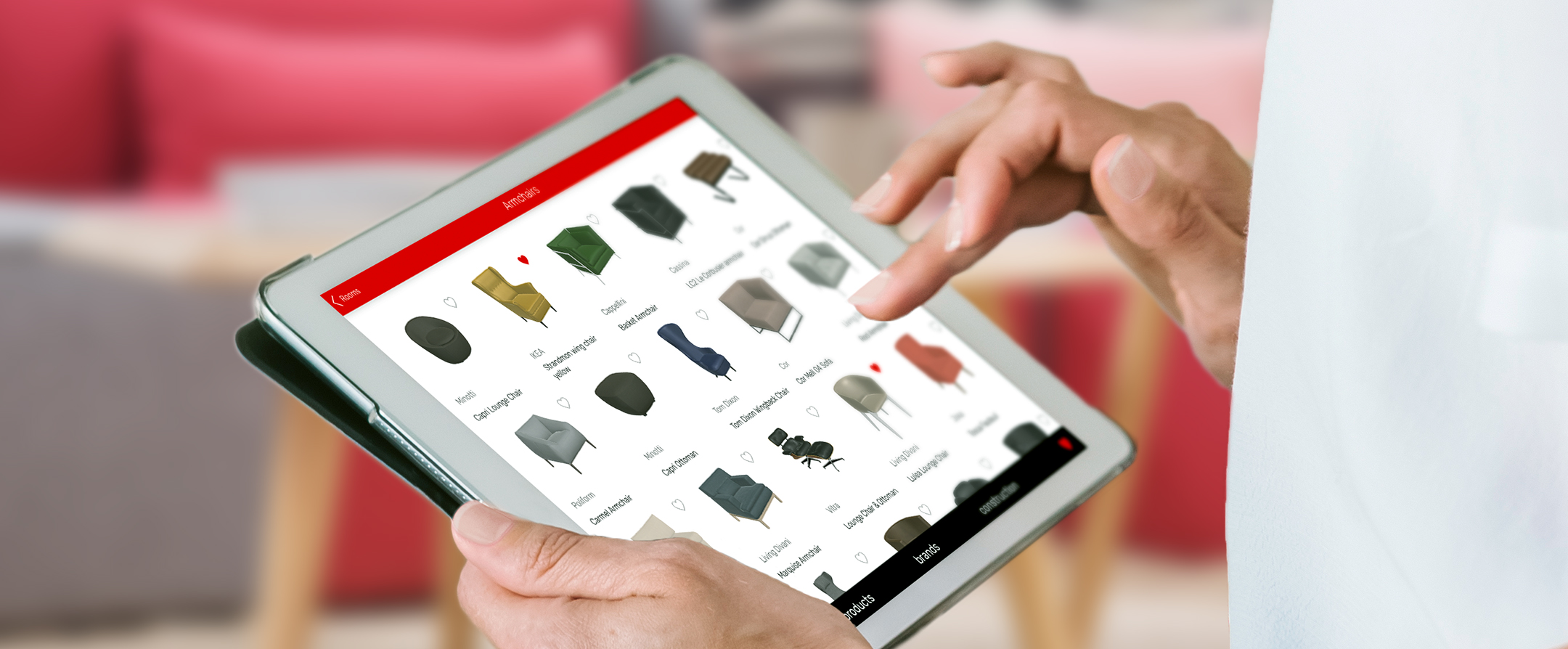 Hand bedient ein Tablet mit der Produktübersicht von Polstermöbeln.