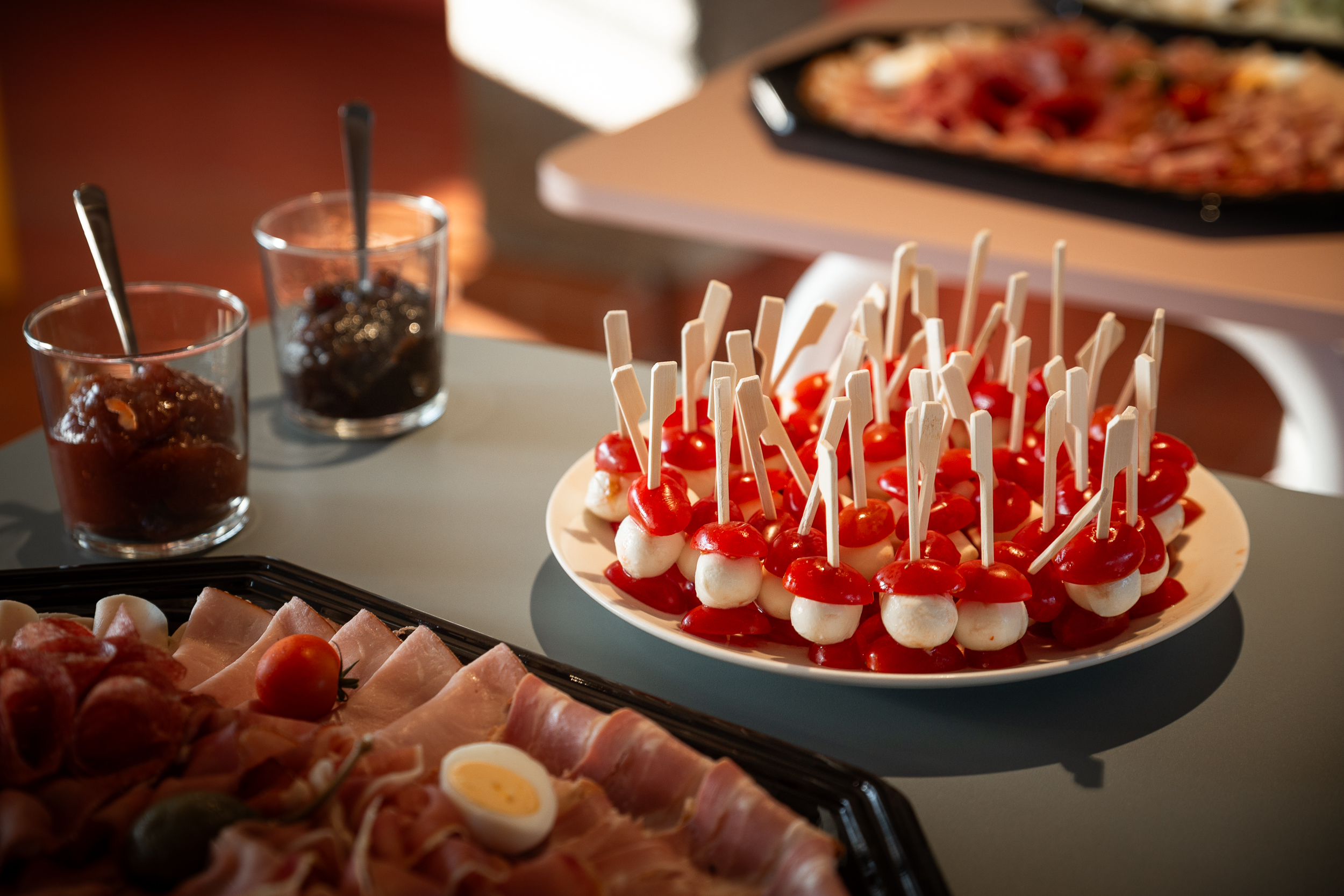 Buffet with antipasti: mini mozzarella skewers, cold cuts, and chutneys at the AI Impulse Breakfast.
