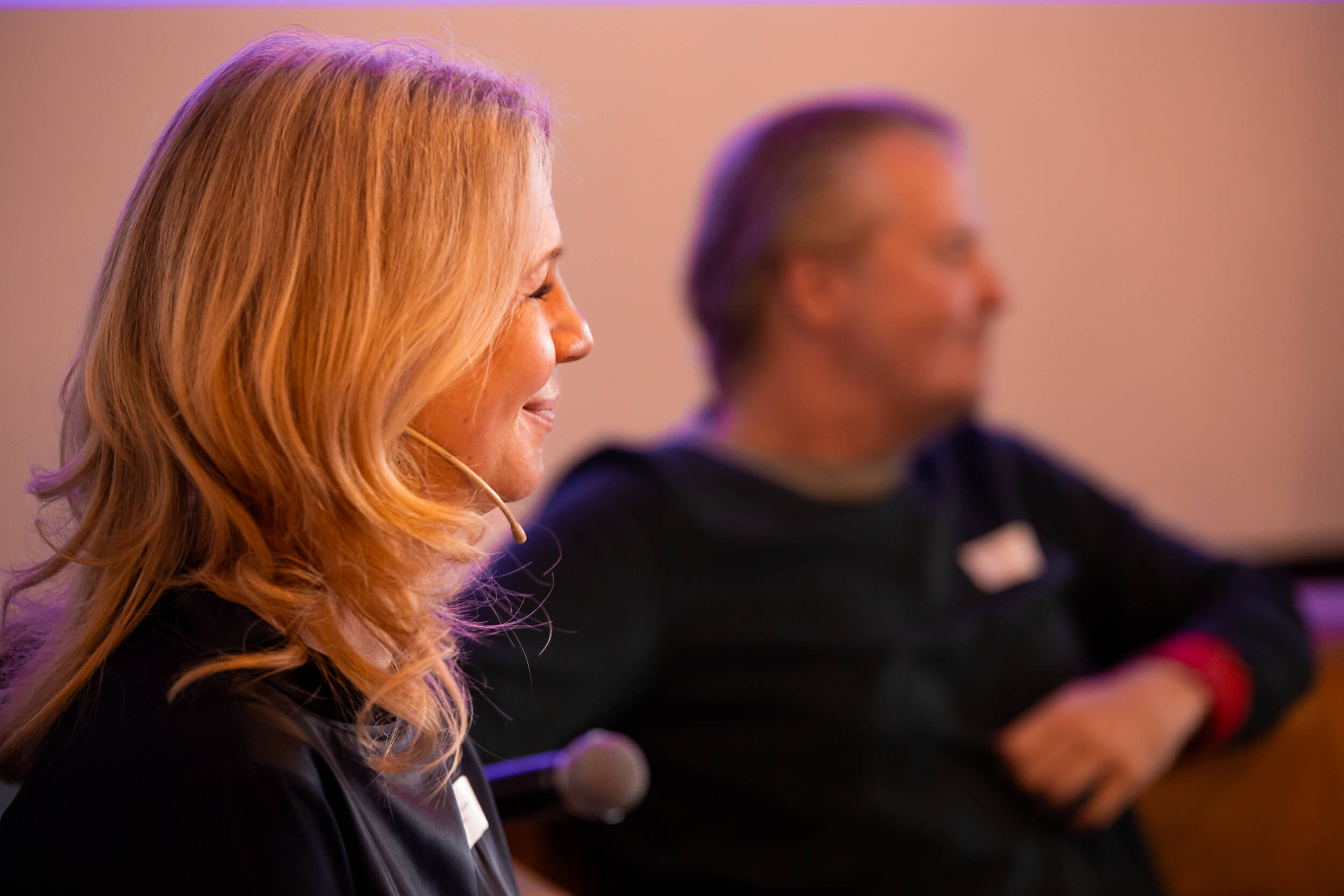 Irene Bouchal-Gahleitner im Profil mit Headset bei der HR Coworking Night, im Hintergrund eine unscharfe Person.