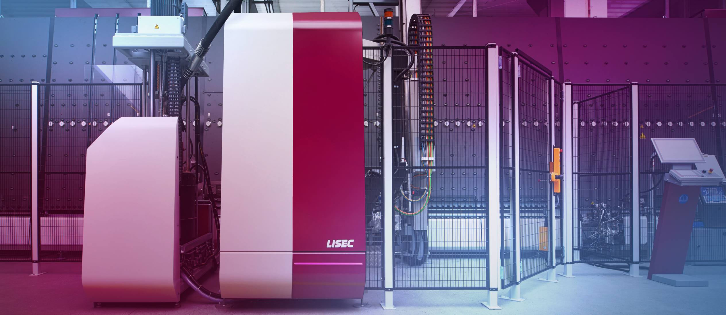 Moderne Glasverarbeitungsmaschine mit rot-weißer Verkleidung in einer industriellen Umgebung, umgeben von Sicherheitszäunen und einer Steuerkonsole mit Touchscreen.