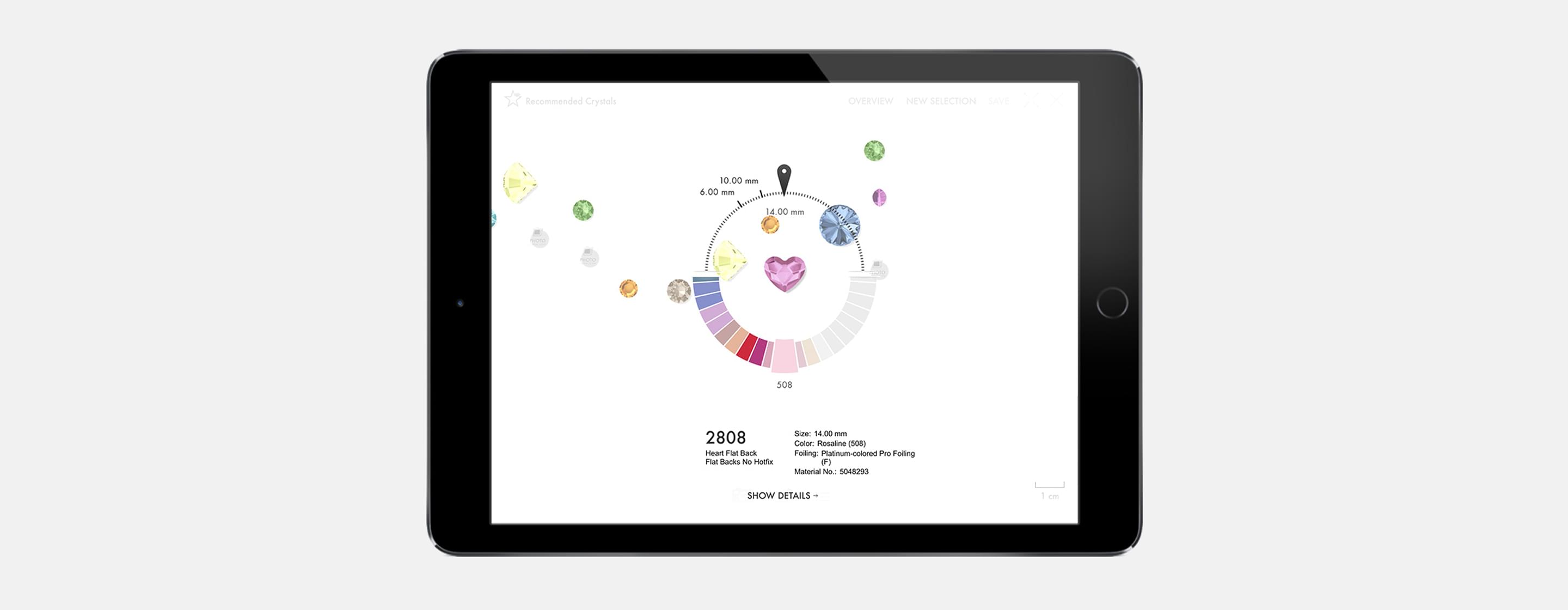 Tablet zeigt farbige Kristalle im Größen- und Farbrad mit Detailanzeige eines rosafarbenen Herzsteins.