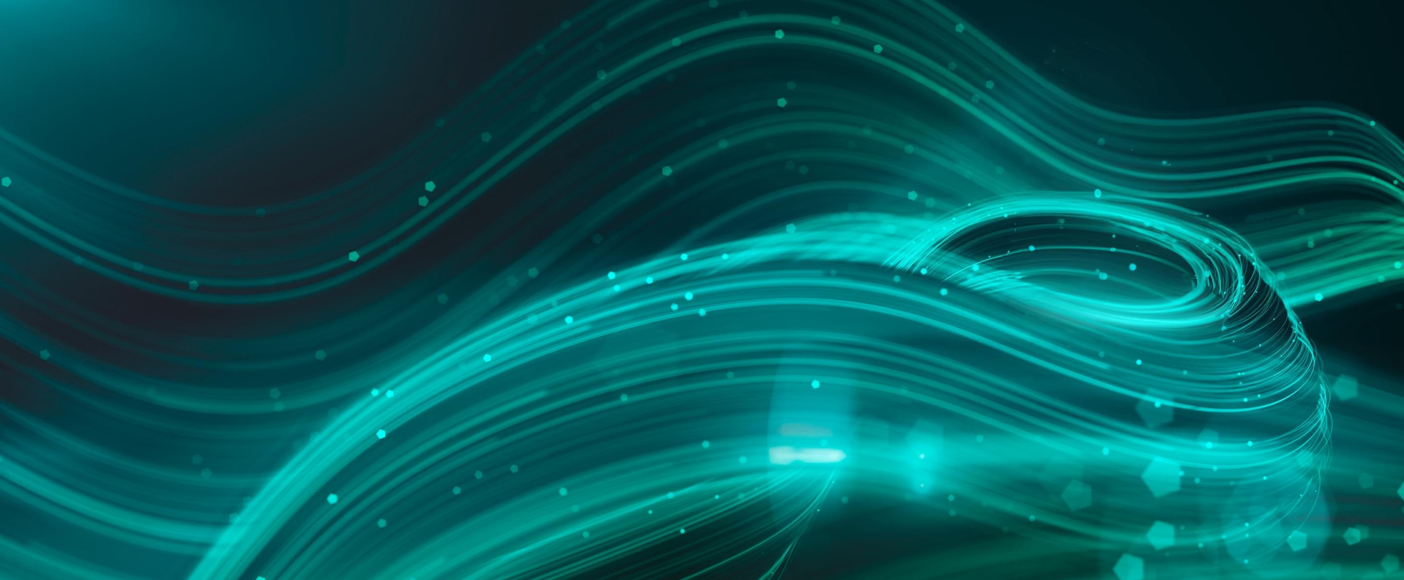 Abstrakte grün-blaue Lichtlinien und Partikel in Wellenform auf dunklem Hintergrund, symbolisieren digitale Dynamik.