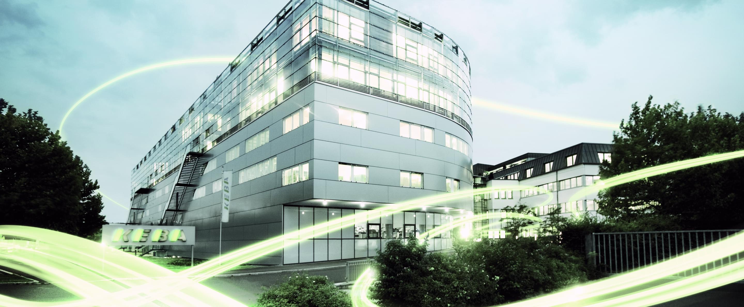 Das KEBA Gebäude von außen mit grünen Lichtbalken um das Gebäude herum