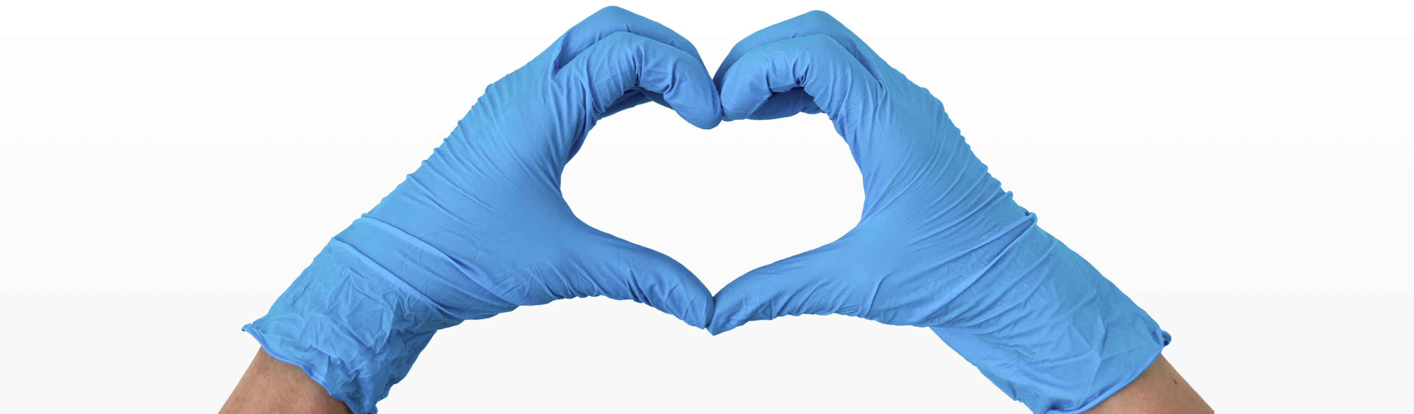 Hände mit Latexhandschuhen bilden ein Herz auf weißem Hintergrund.