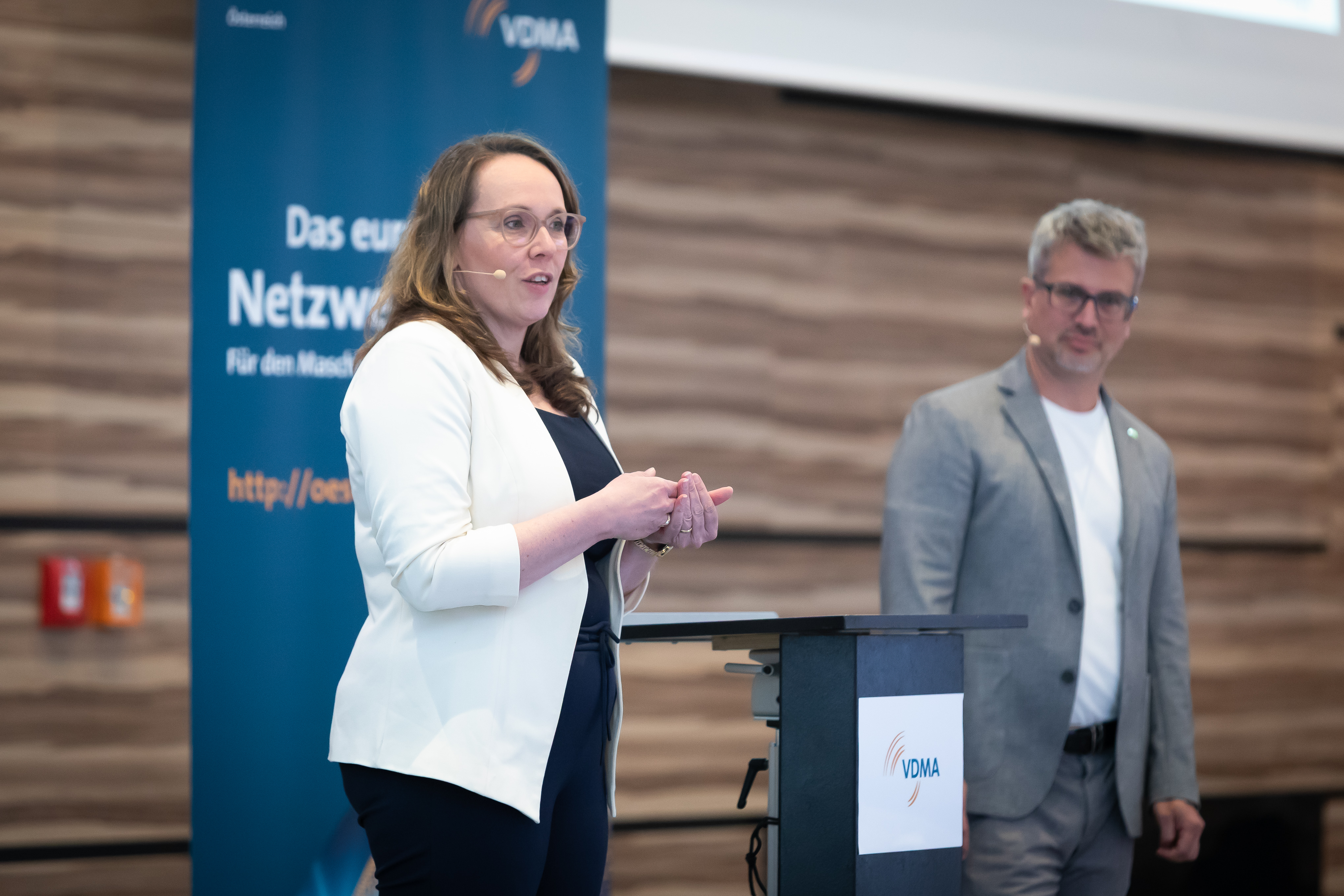 Zwei Sprecher präsentieren auf Bühne beim VDMA-Kongress