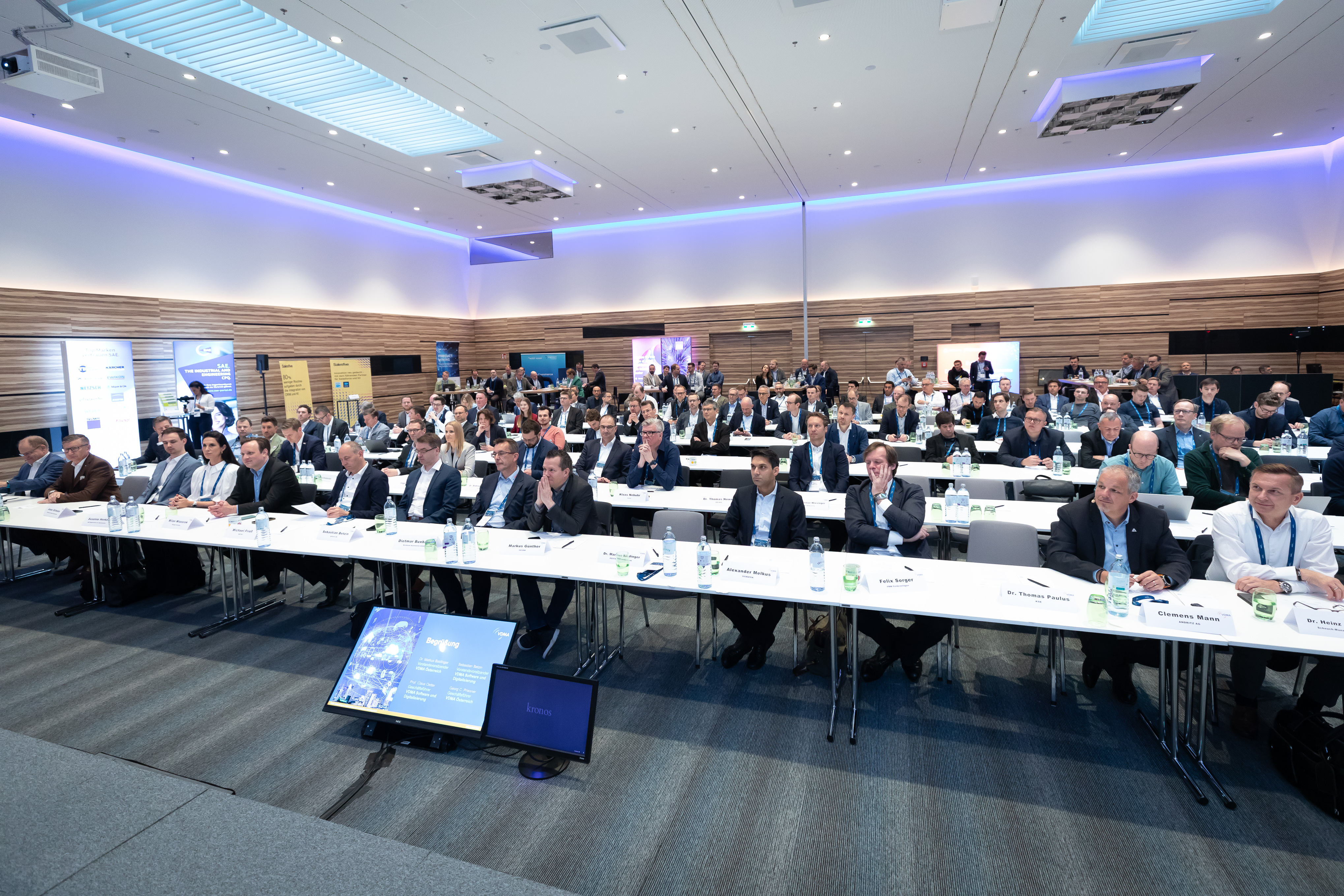 Weitwinkelaufnahme eines voll besetzten Kongressraums mit Publikum