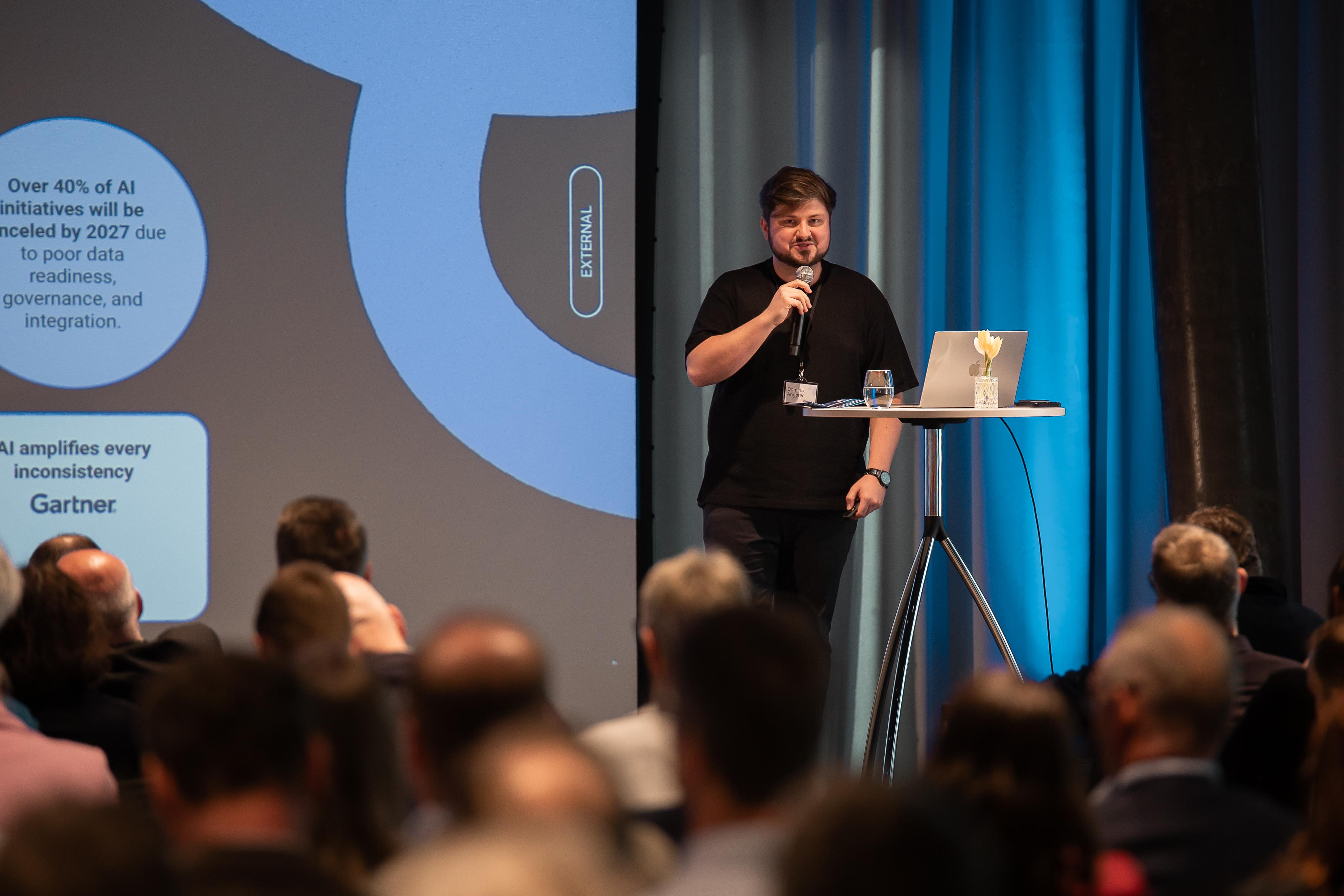Dominik Angerer auf der Bühne des KI Symposiums