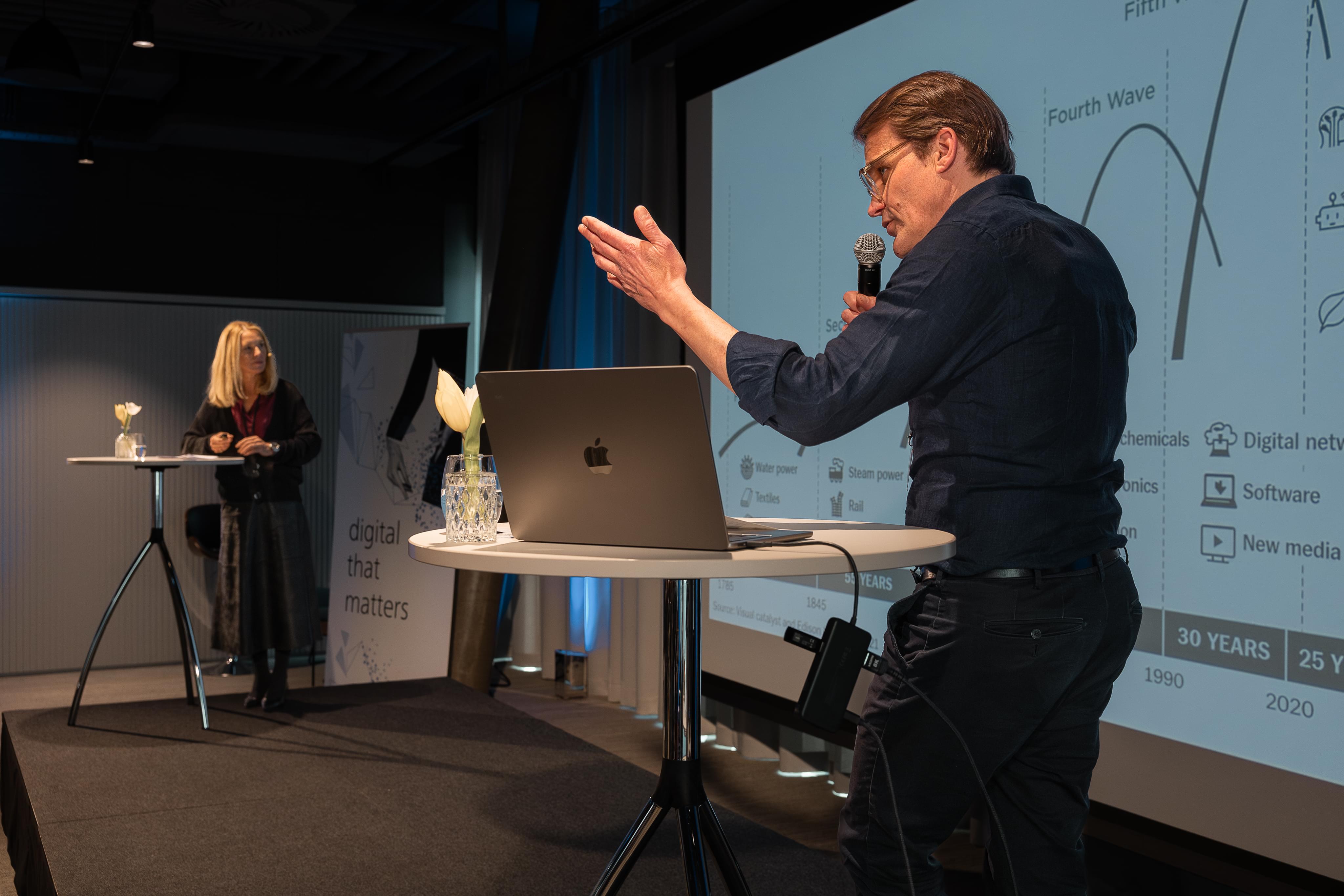 Philip E. Ginthör on stage; Claudia Wintersteiger in the background