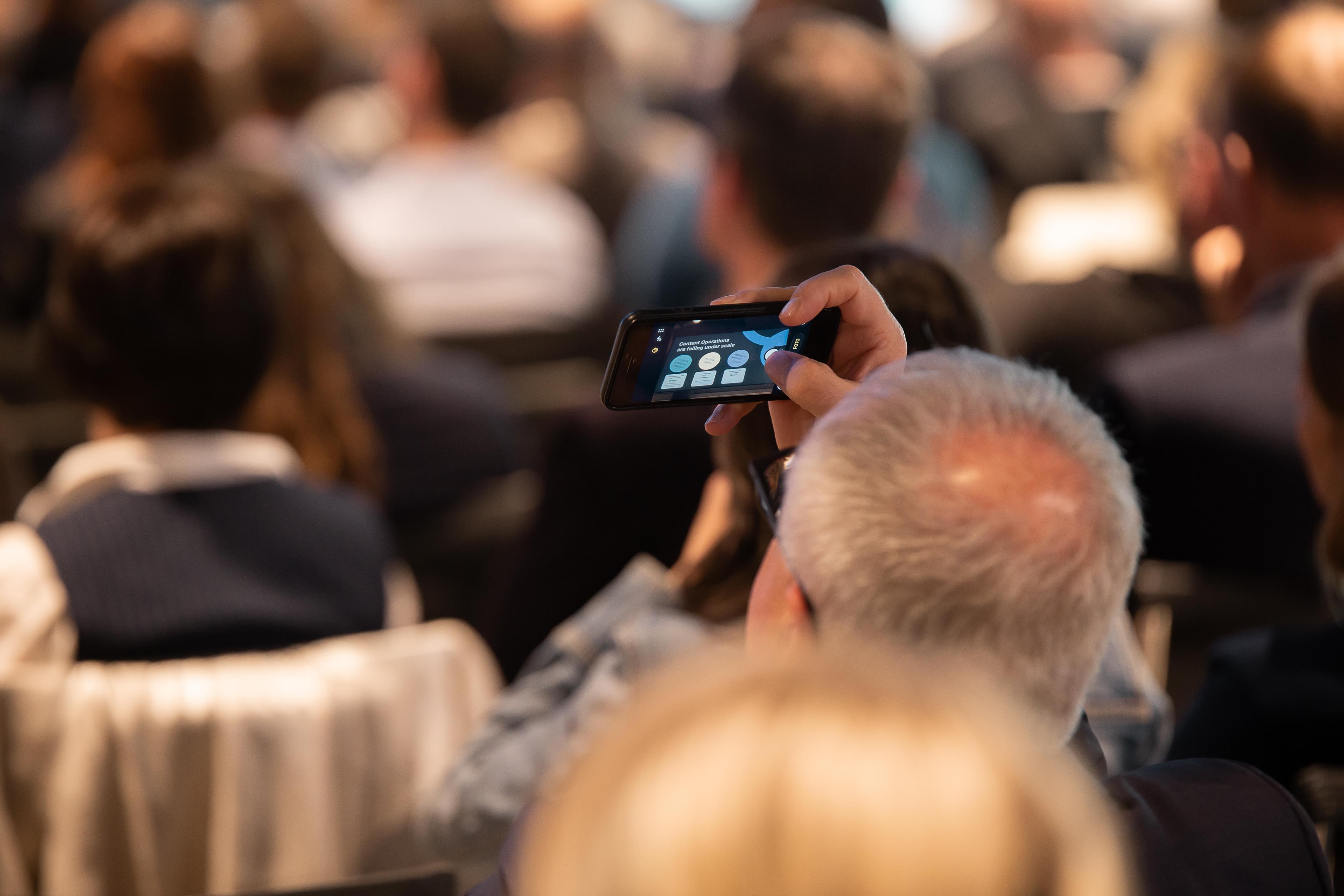 A guest taking a picture during one of the conference talks