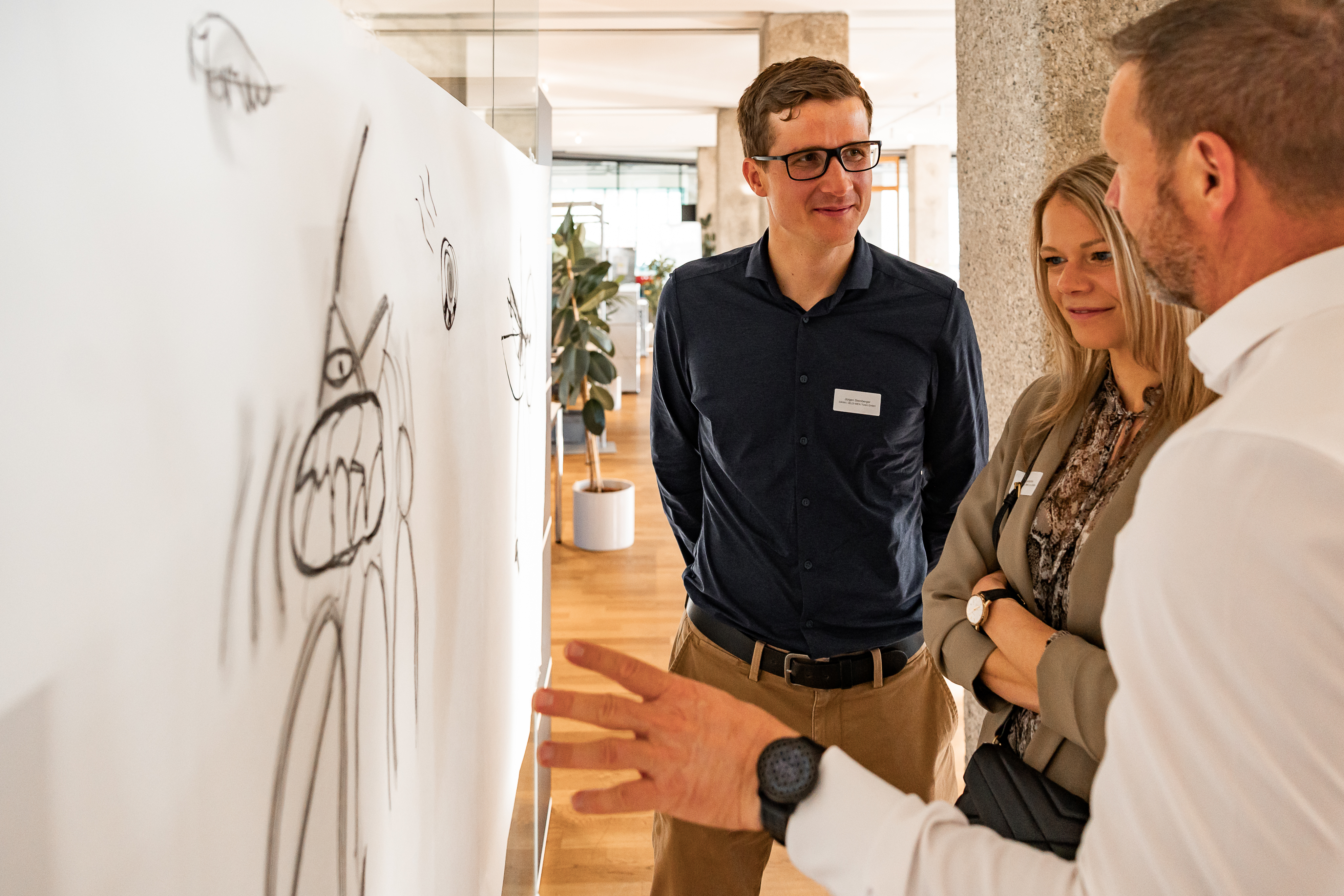 Menschen im Gespräch und Networking im hellen, modernen Netural-Büro bei den Coworking Days in der Tabakfabrik Linz.