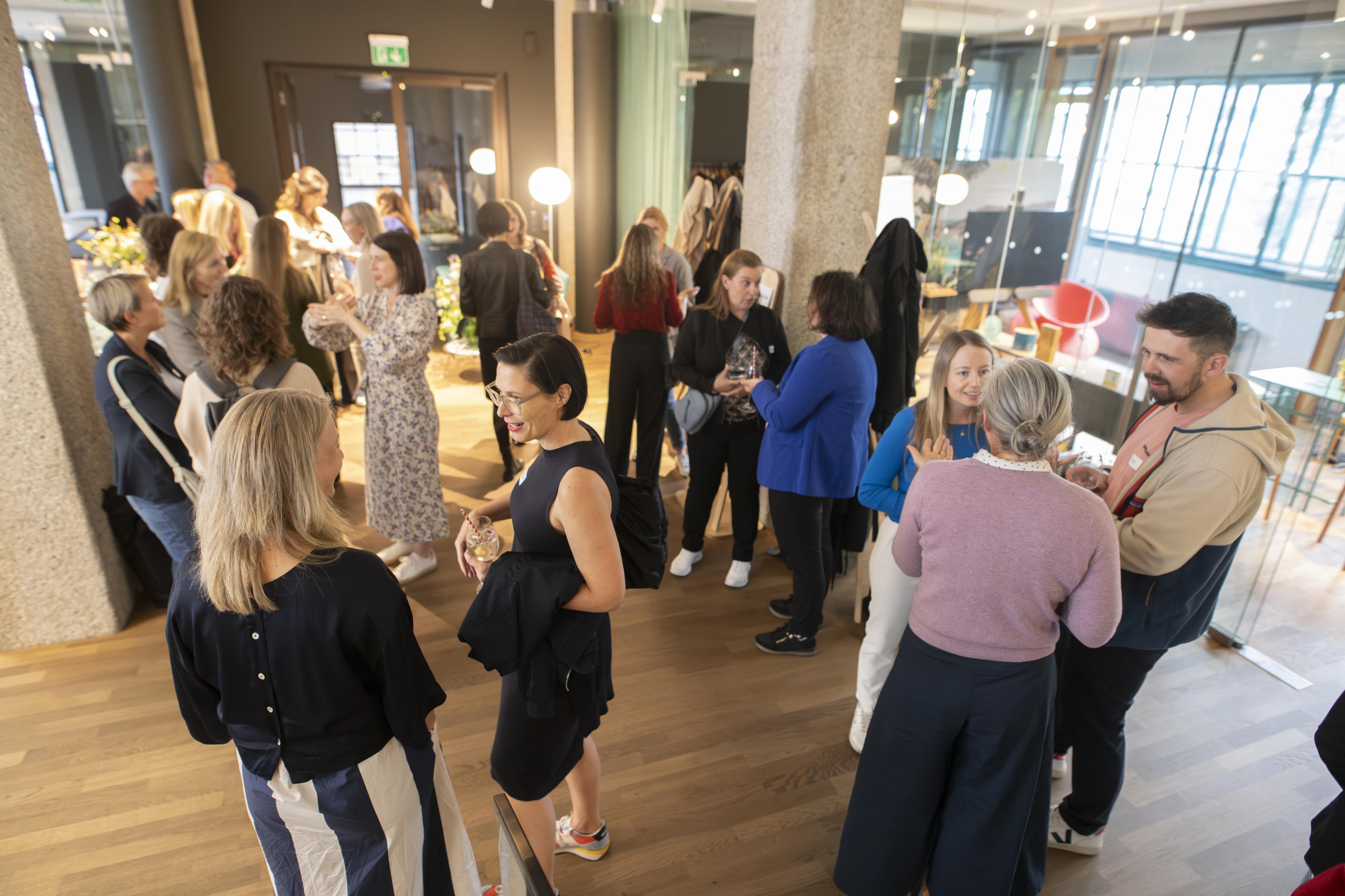 Eine große Gruppe von Personen unterhält sich bei der HR Coworking Night in der Tabakfabrik Linz.