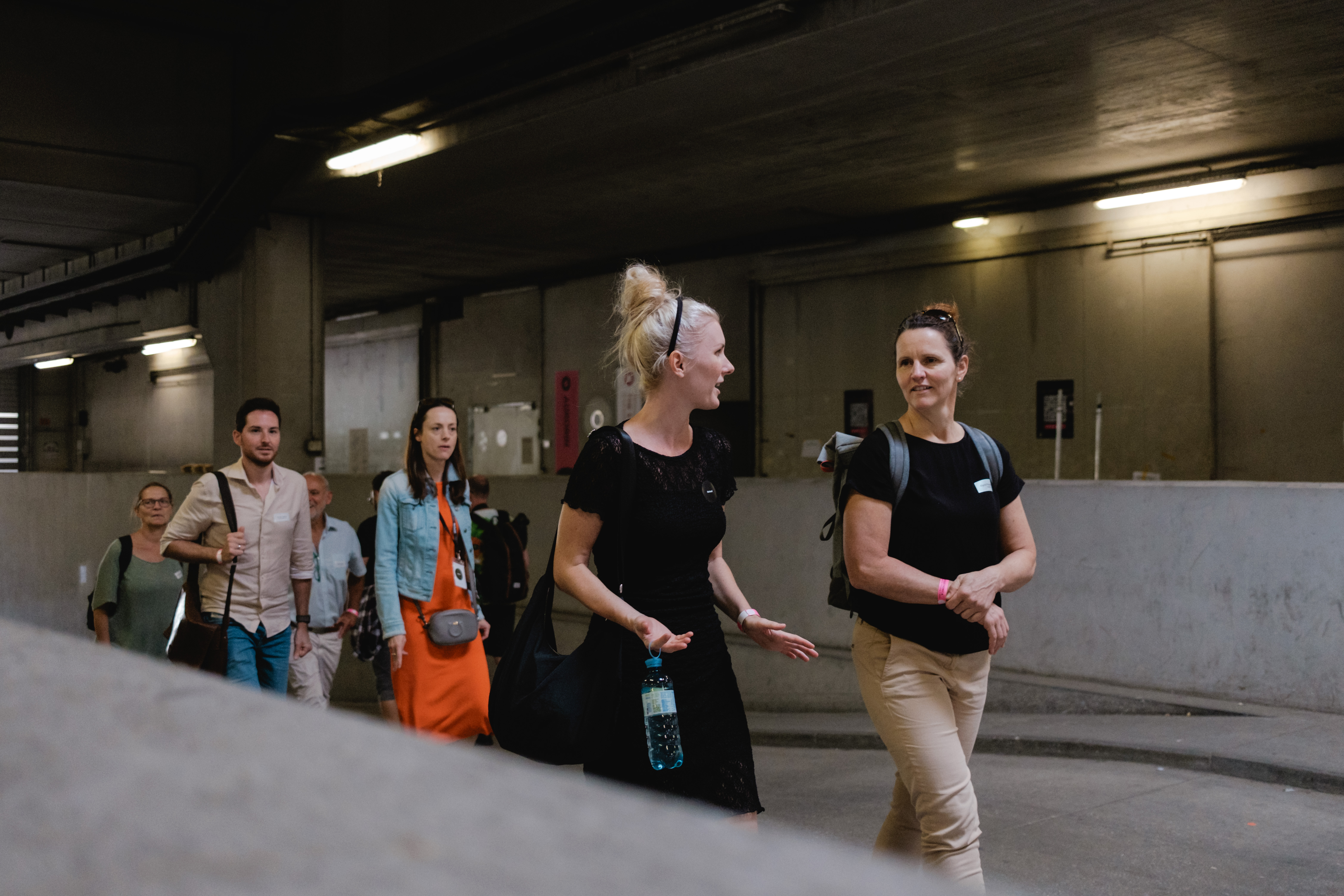 Gruppe Teilnehmender bewegt sich gemeinsam durch einen unterirdischen Gang – auf dem Weg zur nächsten Station.