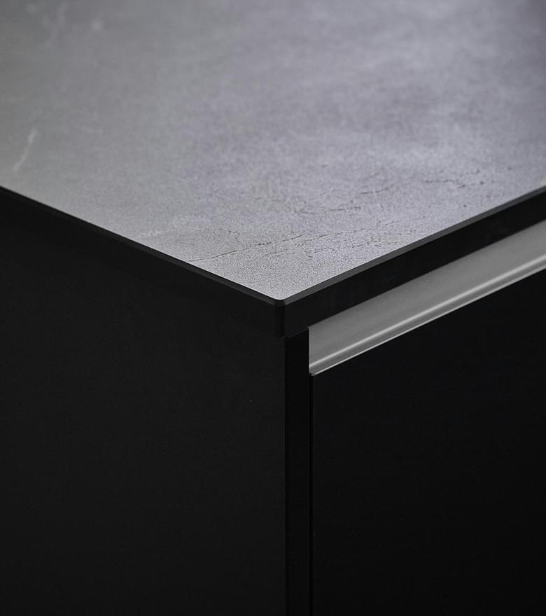 Detailaufnahme einer modernen Küchenarbeitsplatte mit dunkler, matter Oberfläche und klarer Linienführung.