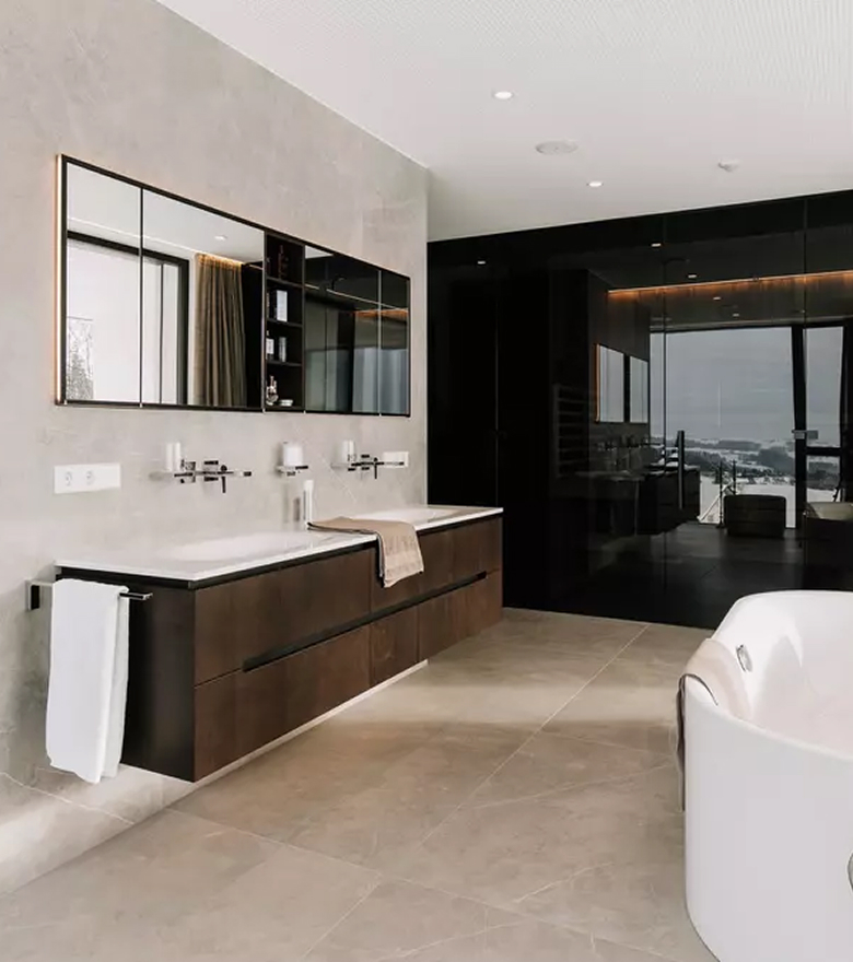 Einblick in ein offenes, modernes Badezimmer mit freistehender Badewanne und Fensterwand.