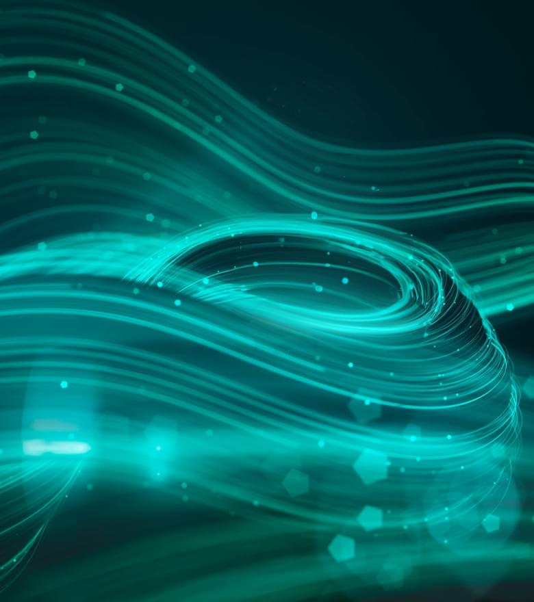 Abstrakte grün-blaue Lichtlinien und Partikel in Wellenform auf dunklem Hintergrund, symbolisieren digitale Dynamik.