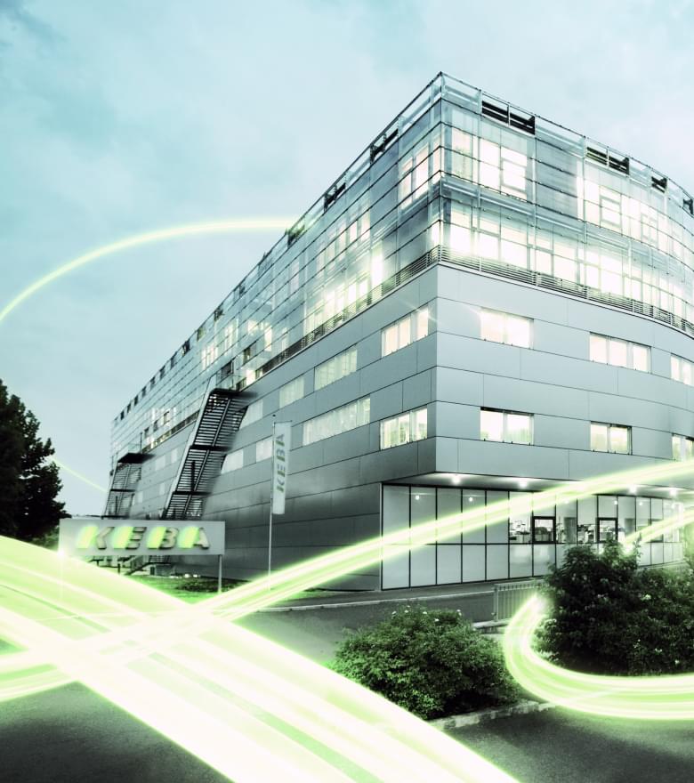 Das KEBA Gebäude von außen mit grünen Lichtbalken um das Gebäude herum