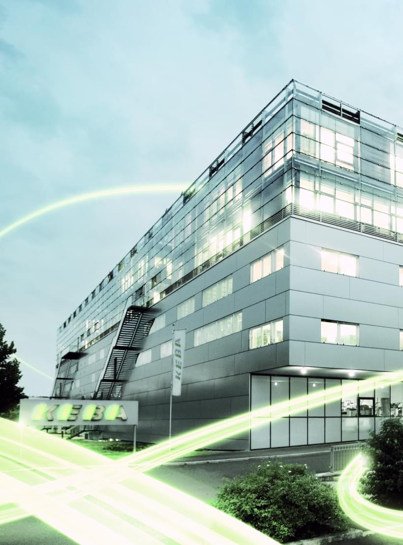 Das KEBA Gebäude von außen mit grünen Lichtbalken um das Gebäude herum