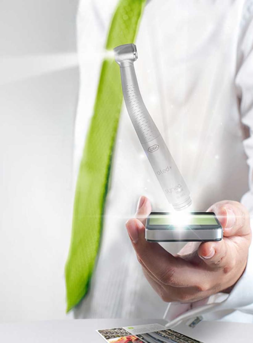 Ein Mann im weißen Laborkittel hält ein beleuchtetes W&H Dentalhandstück – Symbol für Präzision und Innovation.