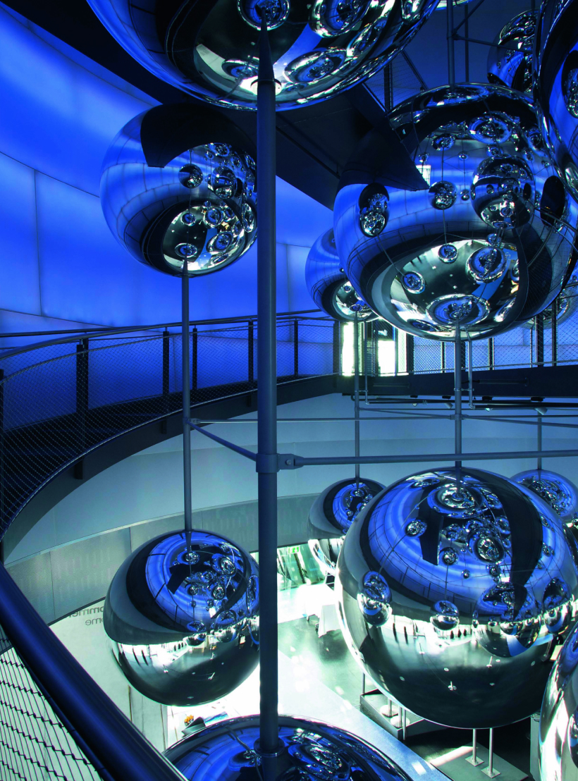 Spiegelnde Metallkugeln und blaue LED-Wände in der modernen Ausstellung voestalpine Stahlwelt