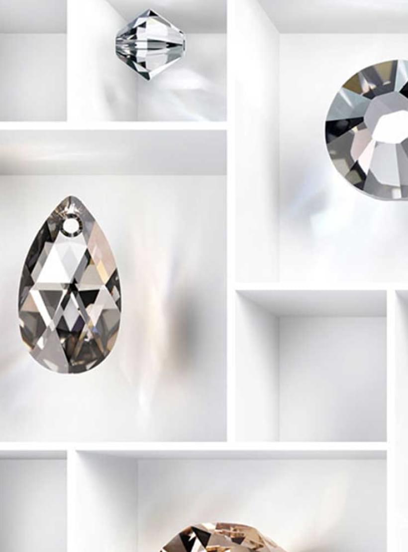 Verschiedene geschliffene Swarovski Kristalle in unterschiedlichen Formen und Farben, arrangiert in einem weißen Fächerkasten.