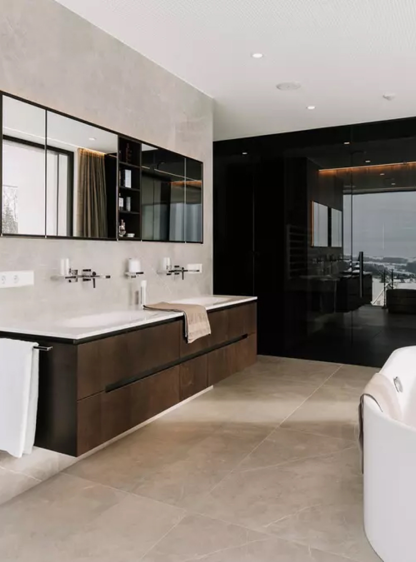 Einblick in ein offenes, modernes Badezimmer mit freistehender Badewanne und Fensterwand.