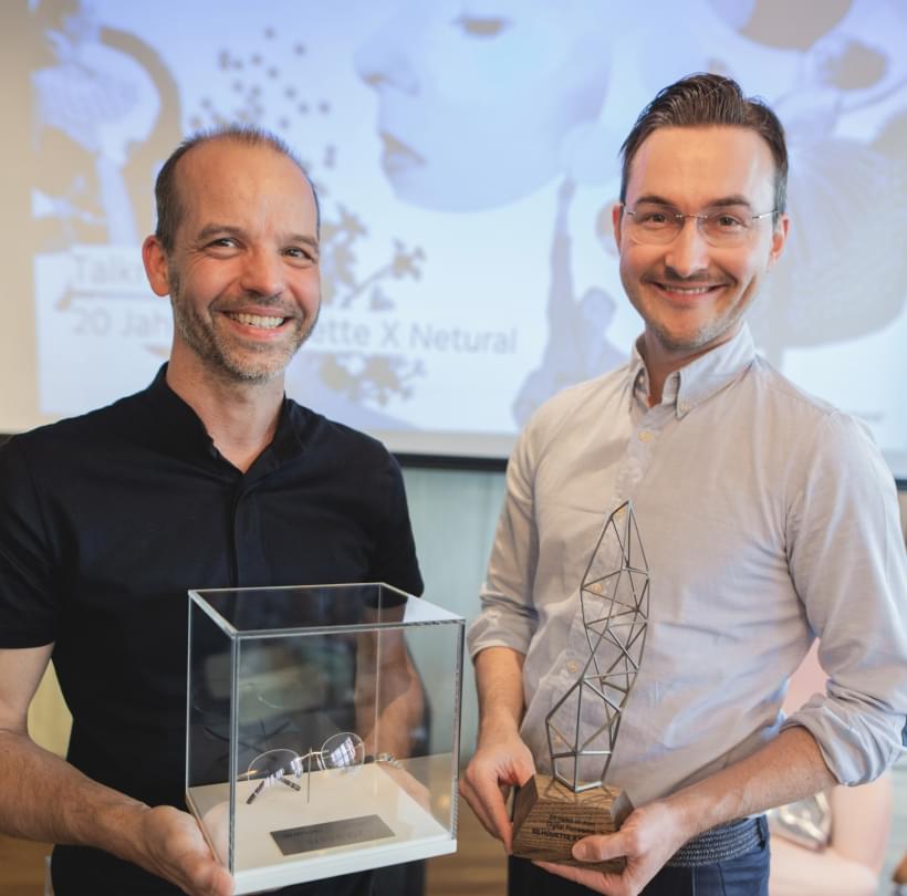 Albert Ortig und Michael Schmied halten Auszeichnungen und lächeln in die Kamera bei „20 Jahre Netural X Netural“.