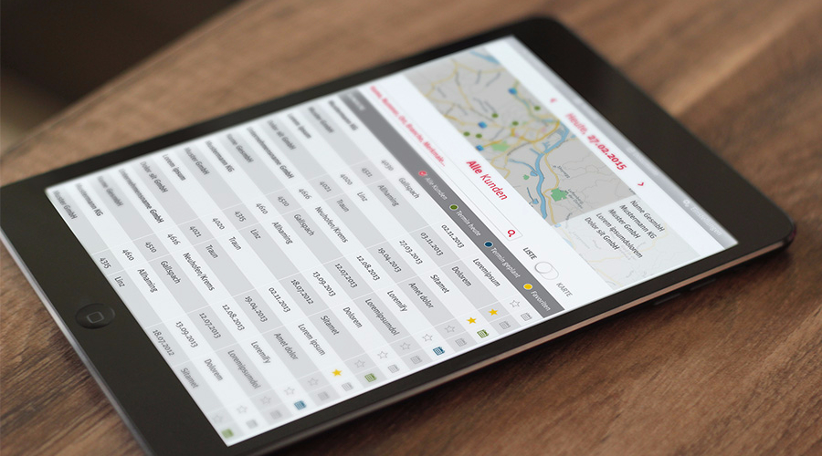 Ein Tablet liegt auf einem dunklen Holztisch, auf dem Bildschirm ist die Benutzeroberfläche der Vertriebsapp zu sehen.